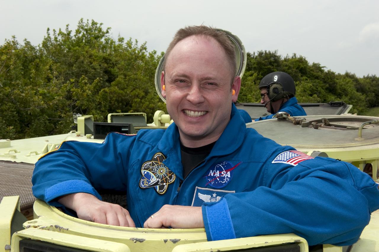 CAPE CANAVERAL, Fla. - STS-134 Mission Specialist Mike Fincke takes time out from driving practice of the M113 armored personnel carrier to pose for a photo at NASA's Kennedy Space Center in Florida. An M113 is kept at the foot of the launch pad in case an emergency exit from the pad is needed and every shuttle crew is trained on driving the vehicle before launch. Space shuttle Endeavour's six crew members are at Kennedy for the launch countdown dress rehearsal called the Terminal Countdown Demonstration Test (TCDT) and related training. Targeted to launch April 19 at 7:48 p.m. EDT, they will deliver the Express Logistics Carrier-3, Alpha Magnetic Spectrometer-2 (AMS), a high-pressure gas tank, additional spare parts for the Dextre robotic helper and micrometeoroid debris shields to the space station. This will be the final spaceflight for Endeavour. For more information visit, www.nasa.gov/mission_pages/shuttle/shuttlemissions/sts134/index.html. Photo credit: NASA/Kim Shiflett
