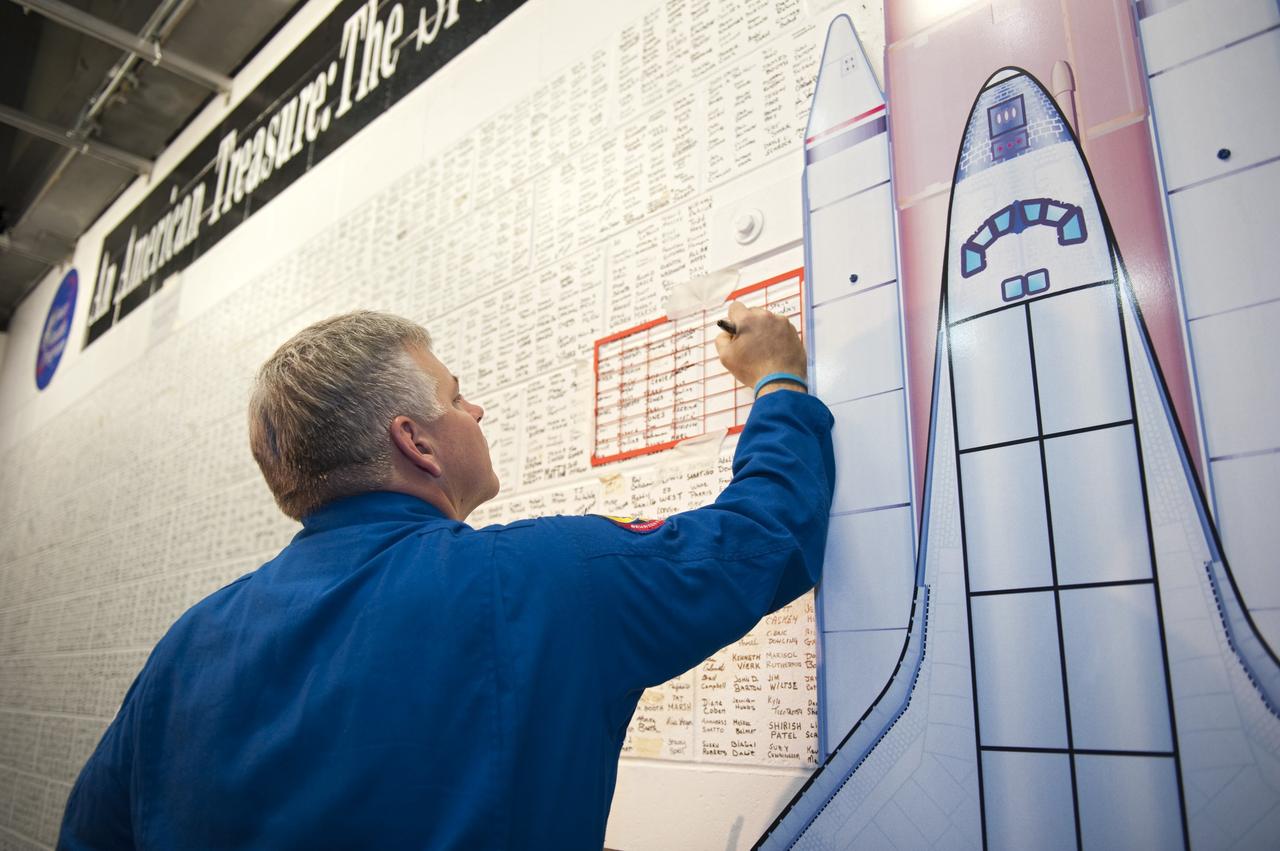CAPE CANAVERAL, Fla. -- STS-134 Pilot Greg H. Johnson signs the space shuttle wall tribute in the Vehicle Assembly Building at NASA's Kennedy Space Center in Florida. Kennedy employees who have supported the Space Shuttle Program throughout the last 30 years have been signing the wall as a tribute to the program. Endeavour's six crew members are at Kennedy for the launch countdown dress rehearsal called the Terminal Countdown Demonstration Test (TCDT) and related training. Endeavour is targeted to launch April 19 at 7:48 p.m. EDT on its final spaceflight mission. For more information visit, www.nasa.gov/mission_pages/shuttle/shuttlemissions/sts134/index.html. Photo credit: NASA/Kim Shiflett