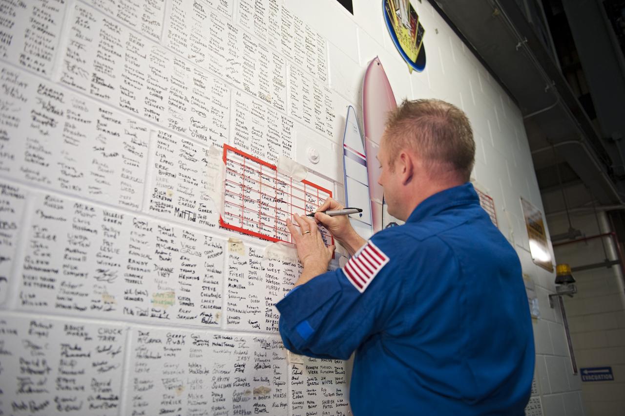 CAPE CANAVERAL, Fla. -- STS-134 Mission Specialist Michael Fincke signs the space shuttle wall tribute in the Vehicle Assembly Building at NASA's Kennedy Space Center in Florida. Kennedy employees who have supported the Space Shuttle Program throughout the last 30 years have been signing the wall as a tribute to the program. Endeavour's six crew members are at Kennedy for the launch countdown dress rehearsal called the Terminal Countdown Demonstration Test (TCDT) and related training. Endeavour is targeted to launch April 19 at 7:48 p.m. EDT on its final spaceflight mission. For more information visit, www.nasa.gov/mission_pages/shuttle/shuttlemissions/sts134/index.html. Photo credit: NASA/Kim Shiflett