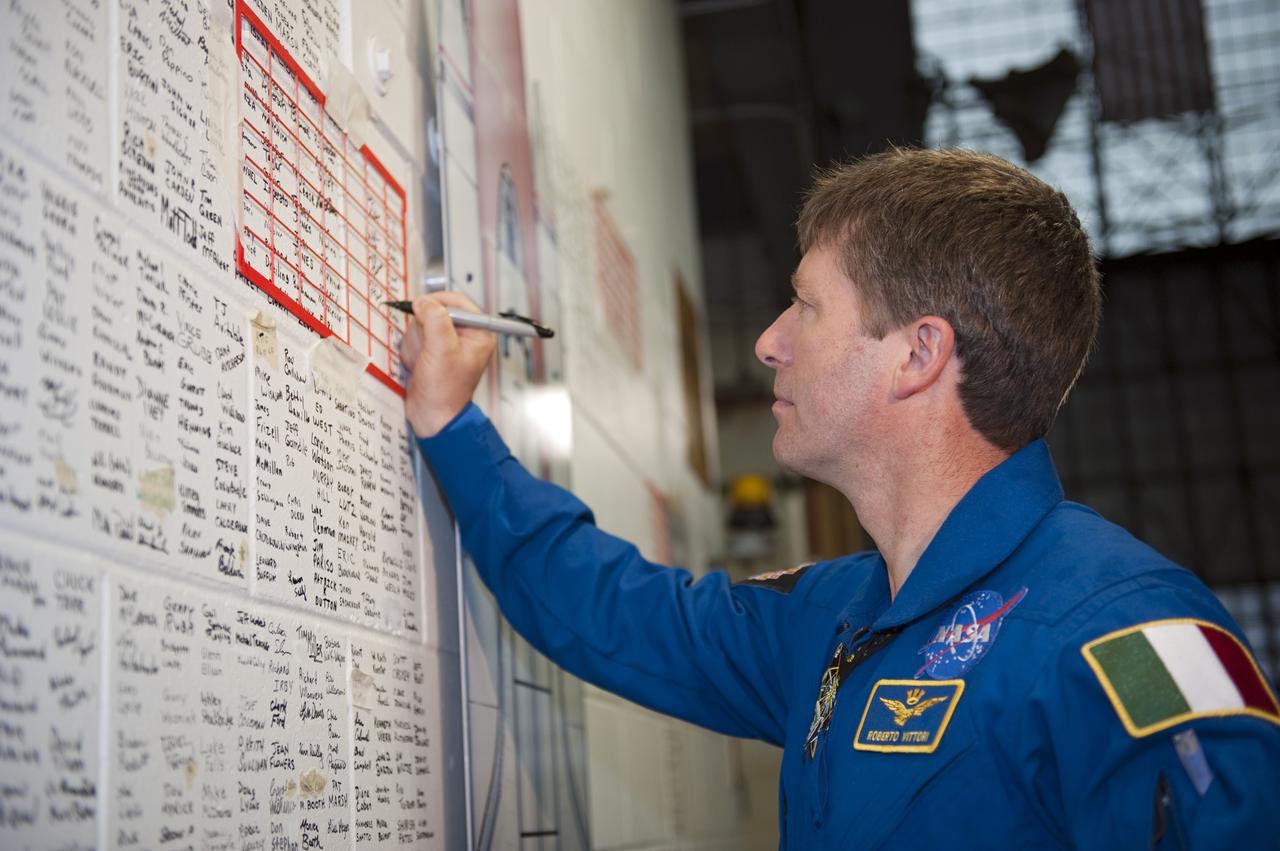 CAPE CANAVERAL, Fla. -- STS-134 Mission Specialist Roberto Vittori, with the European Space Agency, signs the space shuttle wall tribute in the Vehicle Assembly Building at NASA's Kennedy Space Center in Florida. Kennedy employees who have supported the Space Shuttle Program throughout the last 30 years have been signing the wall as a tribute to the program. Endeavour's six crew members are at Kennedy for the launch countdown dress rehearsal called the Terminal Countdown Demonstration Test (TCDT) and related training. Endeavour is targeted to launch April 19 at 7:48 p.m. EDT on its final spaceflight mission. For more information visit, www.nasa.gov/mission_pages/shuttle/shuttlemissions/sts134/index.html. Photo credit: NASA/Kim Shiflett
