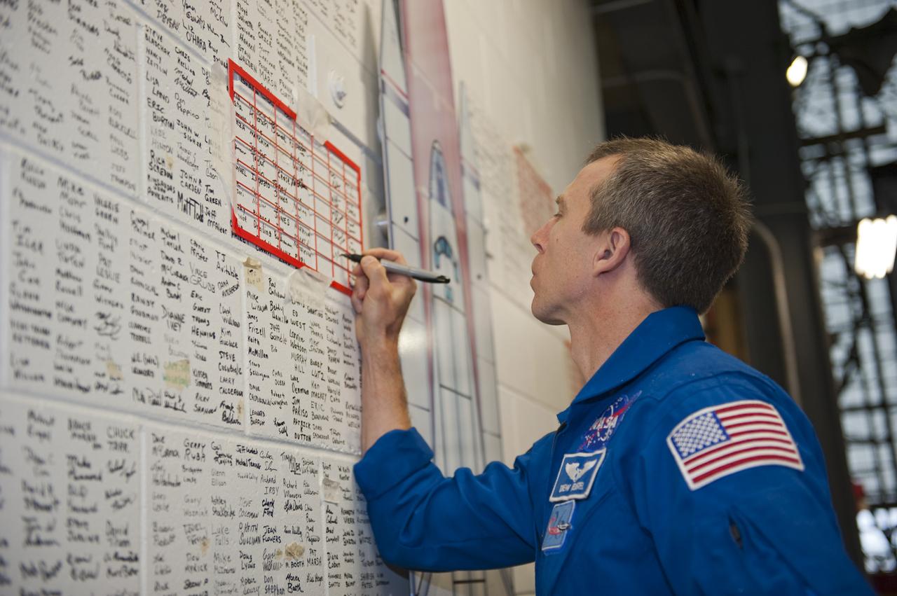 CAPE CANAVERAL, Fla. -- STS-134 Mission Specialist Andrew Feustel signs the space shuttle wall tribute in the Vehicle Assembly Building at NASA's Kennedy Space Center in Florida. Kennedy employees who have supported the Space Shuttle Program throughout the last 30 years have been signing the wall as a tribute to the program. Endeavour's six crew members are at Kennedy for the launch countdown dress rehearsal called the Terminal Countdown Demonstration Test (TCDT) and related training. Endeavour is targeted to launch April 19 at 7:48 p.m. EDT on its final spaceflight mission. For more information visit, www.nasa.gov/mission_pages/shuttle/shuttlemissions/sts134/index.html. Photo credit: NASA/Kim Shiflett