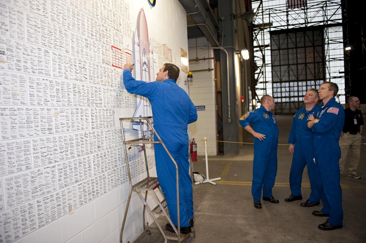 CAPE CANAVERAL, Fla. -- STS-134 Mission Specialist Greg Chamitoff signs the space shuttle wall tribute in the Vehicle Assembly Building at NASA's Kennedy Space Center in Florida. Kennedy employees who have supported the Space Shuttle Program throughout the last 30 years have been signing the wall as a tribute to the program. Endeavour's six crew members are at Kennedy for the launch countdown dress rehearsal called the Terminal Countdown Demonstration Test (TCDT) and related training. Endeavour is targeted to launch April 19 at 7:48 p.m. EDT on its final spaceflight mission. For more information visit, www.nasa.gov/mission_pages/shuttle/shuttlemissions/sts134/index.html. Photo credit: NASA/Kim Shiflett