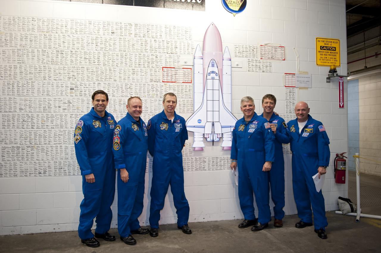 CAPE CANAVERAL, Fla. -- The STS-134 crew members pose in front of the space shuttle wall tribute in the Vehicle Assembly Building at NASA's Kennedy Space Center in Florida. Kennedy employees who have supported the Space Shuttle Program throughout the last 30 years have been signing the wall as a tribute to the program. From left, are Mission Specialists Greg Chamitoff, Michael Fincke, Andrew Feustel, Pilot Greg H. Johnson, Mission Specialist Roberto Vittori, with the European Space Agency, and Commander Mark Kelly. Endeavour's six crew members are at Kennedy for the launch countdown dress rehearsal called the Terminal Countdown Demonstration Test (TCDT) and related training. Endeavour is targeted to launch April 19 at 7:48 p.m. EDT on its final spaceflight mission. For more information visit, www.nasa.gov/mission_pages/shuttle/shuttlemissions/sts134/index.html. Photo credit: NASA/Kim Shiflett