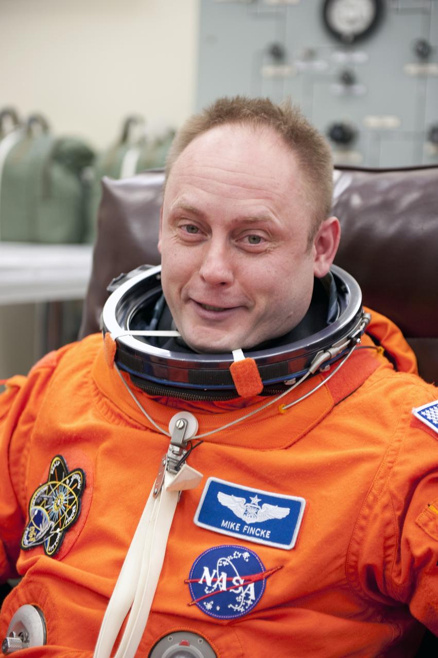 CAPE CANAVERAL, Fla. -- During a simulated launch countdown, STS-134 Mission Specialist Michael Fincke checks the fit of his bright-orange, launch-and-entry suit in the Operations and Checkout Building at NASA's Kennedy Space Center in Florida. Next, Fincke and his crewmates will walk out to the waiting Astrovan. As part of the Terminal Countdown Demonstration Test (TCDT), the crew members will ride to the pad in their silver Astrovan and strap into space shuttle Endeavour to practice the steps that will be taken on launch day. Endeavour's six crew members are targeted to launch April 19 at 7:48 p.m. EDT. They will deliver the Express Logistics Carrier-3, Alpha Magnetic Spectrometer-2 (AMS), a high-pressure gas tank, additional spare parts for the Dextre robotic helper and micrometeoroid debris shields to the International Space Station. This will be the final spaceflight for Endeavour. For more information visit, www.nasa.gov/mission_pages/shuttle/shuttlemissions/sts134/index.html. Photo credit: NASA/Kim Shiflett