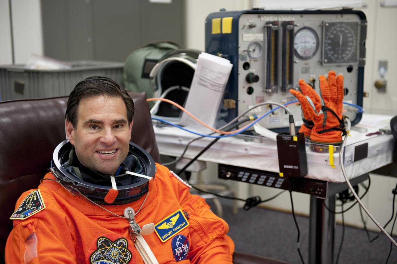 CAPE CANAVERAL, Fla. -- During a simulated launch countdown, STS-134 Mission Specialist Greg Chamitoff checks the fit of his bright-orange, launch-and-entry suit in the Operations and Checkout Building at NASA's Kennedy Space Center in Florida. Next, Chamitoff and his crewmates will walk out to the waiting Astrovan. As part of the Terminal Countdown Demonstration Test (TCDT), the crew members will ride to the pad in their silver Astrovan and strap into space shuttle Endeavour to practice the steps that will be taken on launch day. Endeavour's six crew members are targeted to launch April 19 at 7:48 p.m. EDT. They will deliver the Express Logistics Carrier-3, Alpha Magnetic Spectrometer-2 (AMS), a high-pressure gas tank, additional spare parts for the Dextre robotic helper and micrometeoroid debris shields to the International Space Station. This will be the final spaceflight for Endeavour. For more information visit, www.nasa.gov/mission_pages/shuttle/shuttlemissions/sts134/index.html. Photo credit: NASA/Kim Shiflett