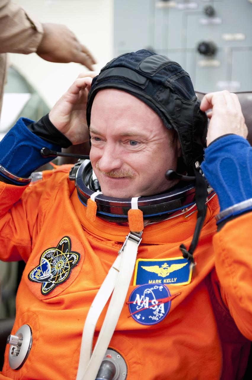 CAPE CANAVERAL, Fla. -- During a simulated launch countdown, STS-134 Commander Mark Kelly checks the fit of his bright-orange, launch-and-entry suit and communications cap in the Operations and Checkout Building at NASA's Kennedy Space Center in Florida. Next, Kelly and his crewmates will walk out to the waiting Astrovan. As part of the Terminal Countdown Demonstration Test (TCDT), the crew members will ride to the pad in their silver Astrovan and strap into space shuttle Endeavour to practice the steps that will be taken on launch day. Endeavour's six crew members are targeted to launch April 19 at 7:48 p.m. EDT. They will deliver the Express Logistics Carrier-3, Alpha Magnetic Spectrometer-2 (AMS), a high-pressure gas tank, additional spare parts for the Dextre robotic helper and micrometeoroid debris shields to the International Space Station. This will be the final spaceflight for Endeavour. For more information visit, www.nasa.gov/mission_pages/shuttle/shuttlemissions/sts134/index.html. Photo credit: NASA/Kim Shiflett