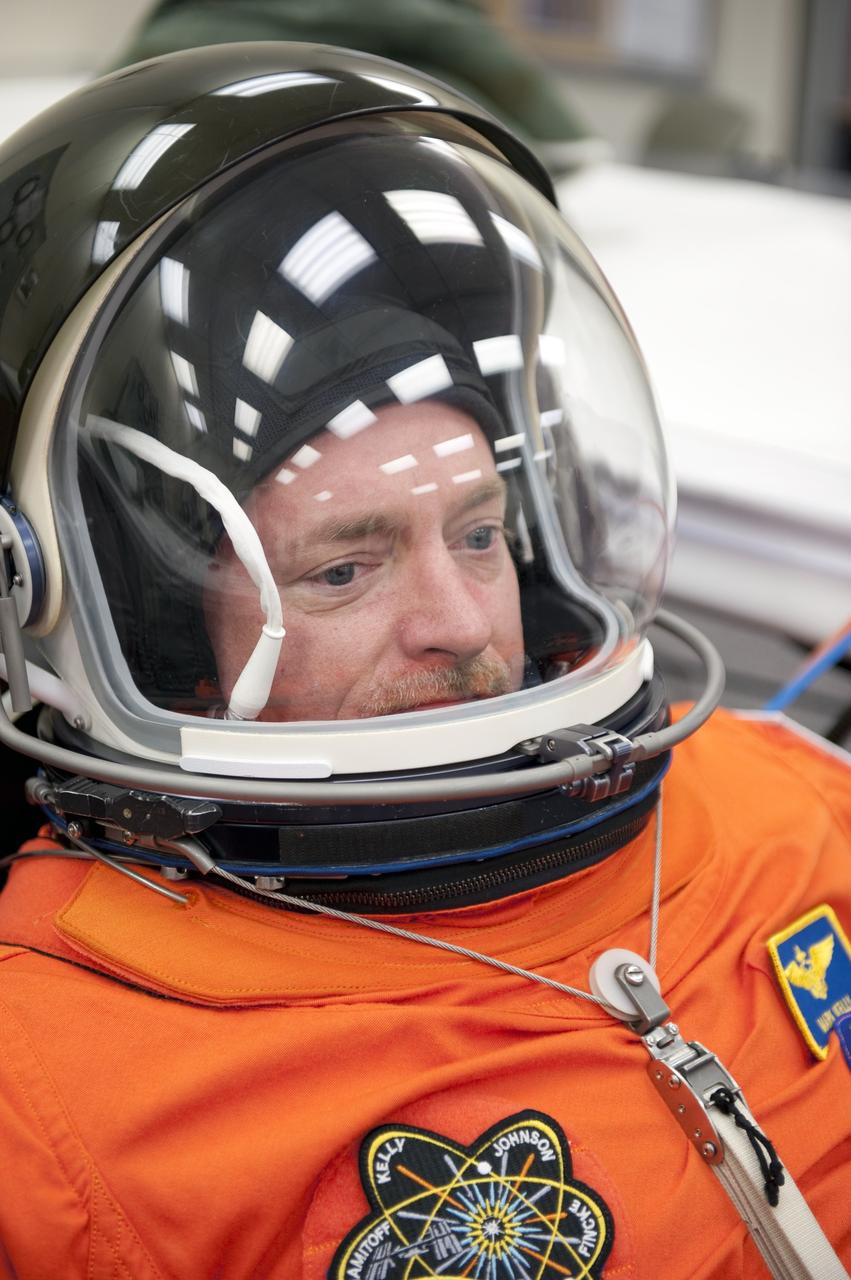 CAPE CANAVERAL, Fla. -- During a simulated launch countdown, STS-134 Commander Mark Kelly checks the fit of his bright-orange, launch-and-entry suit and communications cap in the Operations and Checkout Building at NASA's Kennedy Space Center in Florida. Next, Kelly and his crewmates will walk out to the waiting Astrovan. As part of the Terminal Countdown Demonstration Test (TCDT), the crew members will ride to the pad in their silver Astrovan and strap into space shuttle Endeavour to practice the steps that will be taken on launch day. Endeavour's six crew members are targeted to launch April 19 at 7:48 p.m. EDT. They will deliver the Express Logistics Carrier-3, Alpha Magnetic Spectrometer-2 (AMS), a high-pressure gas tank, additional spare parts for the Dextre robotic helper and micrometeoroid debris shields to the International Space Station. This will be the final spaceflight for Endeavour. For more information visit, www.nasa.gov/mission_pages/shuttle/shuttlemissions/sts134/index.html. Photo credit: NASA/Kim Shiflett