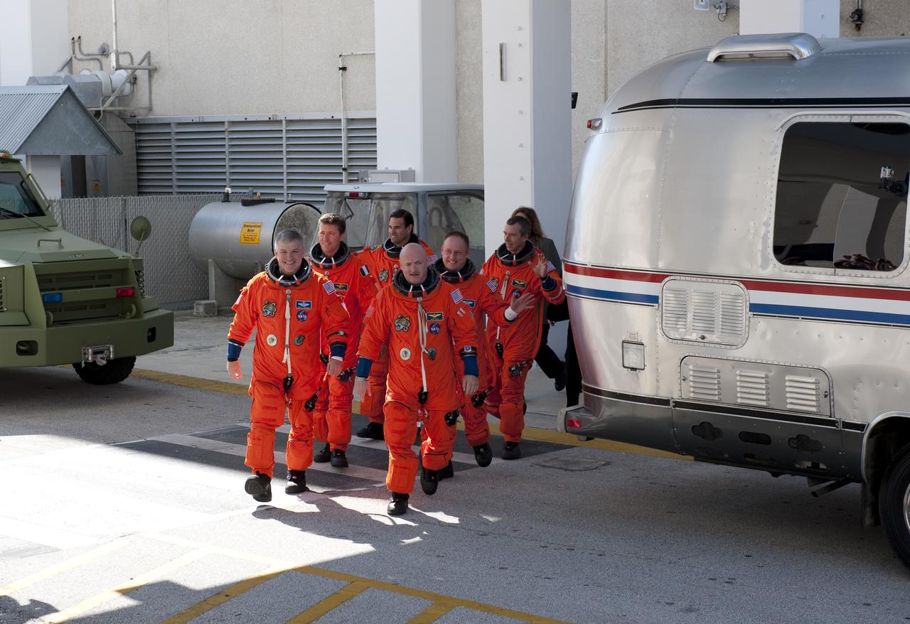 CAPE CANAVERAL, Fla. -- During a simulated launch countdown, the STS-134 crew walks out of the Operations and Checkout Building to the waiting Astrovan at NASA's Kennedy Space Center in Florida. As part of the Terminal Countdown Demonstration Test (TCDT), the crew members ride to Kennedy's Launch Pad 39A in the silver vehicle and strap into space shuttle Endeavour to practice the steps that will be taken on launch day. From front, left to right, are STS-134 Pilot Greg H. Johnson, Commander Mark Kelly; second row; astronaut Roberto Vittori from the European Space Agency and Mission Specialist Mike Fincke; third row are Mission Specialists Greg Chamitoff and Andrew Feustel. Endeavour's six crew members are targeted to launch April 19 at 7:48 p.m. EDT. They will deliver the Express Logistics Carrier-3, Alpha Magnetic Spectrometer-2 (AMS), a high-pressure gas tank, additional spare parts for the Dextre robotic helper and micrometeoroid debris shields to the International Space Station. This will be the final spaceflight for Endeavour. For more information visit, www.nasa.gov/mission_pages/shuttle/shuttlemissions/sts134/index.html. Photo credit: NASA/Kim Shiflett