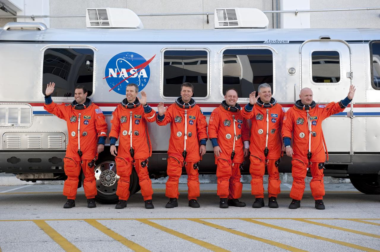 CAPE CANAVERAL, Fla. -- During a simulated launch countdown, the STS-134 crew pause for a photo opportunity before climbing onboard the Astrovan at NASA's Kennedy Space Center in Florida. As part of the Terminal Countdown Demonstration Test (TCDT), the crew members ride to Kennedy's Launch Pad 39A in the silver vehicle and strap into space shuttle Endeavour to practice the steps that will be taken on launch day. From right to left are, Commander Mark Kelly, Pilot Greg H. Johnson , Mission Specialist Mike Fincke,  Roberto Vittori, European Space Agency astronaut, and Mission Specialists Andrew Feustel and Greg Chamitoff.        Endeavour's six crew members are targeted to launch April 19 at 7:48 p.m. EDT. They will deliver the Express Logistics Carrier-3, Alpha Magnetic Spectrometer-2 (AMS), a high-pressure gas tank, additional spare parts for the Dextre robotic helper and micrometeoroid debris shields to the International Space Station. This will be the final spaceflight for Endeavour. For more information visit, www.nasa.gov/mission_pages/shuttle/shuttlemissions/sts134/index.html. Photo credit: NASA/Kim Shiflett
