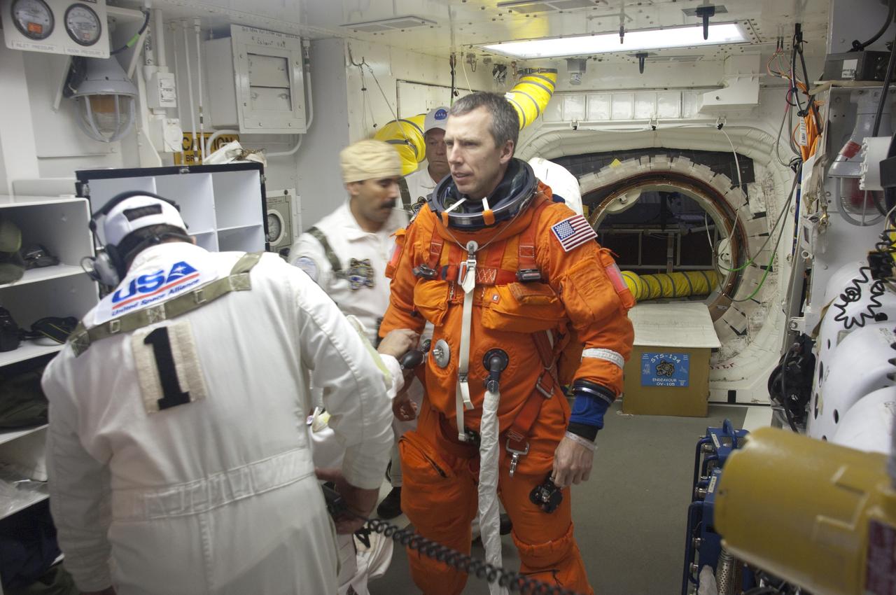 CAPE CANAVERAL, Fla. -- In the White Room of Launch Pad 39A at NASA's Kennedy Space Center in Florida, the Closeout Crew helps STS-134 Mission Specialist Andrew Feustel put on the parachute for his launch-and-entry suit before he boards space shuttle Endeavour during the Terminal Countdown Demonstration Test (TCDT). Part of TCDT includes practicing the final hours of a real launch day when astronauts put on their launch-and-entry suits, ride to the pad in the Astrovan and strap into the shuttle.    Endeavour's six crew members are targeted to launch April 19 at 7:48 p.m. EDT. They will deliver the Express Logistics Carrier-3, Alpha Magnetic Spectrometer-2 (AMS), a high-pressure gas tank, additional spare parts for the Dextre robotic helper and micrometeoroid debris shields to the International Space Station. This will be the final spaceflight for Endeavour. For more information visit, www.nasa.gov/mission_pages/shuttle/shuttlemissions/sts134/index.html. Photo credit: NASA/Kevin O'Connell