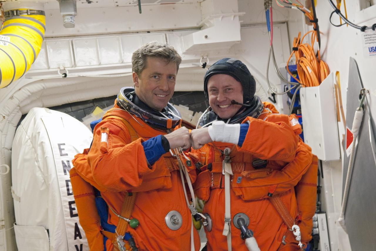 CAPE CANAVERAL, Fla. -- In the White Room of Launch Pad 39A at NASA's Kennedy Space Center in Florida, STS-134 Mission Specialists Roberto Vittori, with the European Space Agency, left, and Michael Fincke touch fists as they prepare to board space shuttle Endeavour during the Terminal Countdown Demonstration Test (TCDT). Part of TCDT includes practicing the final hours of a real launch day when astronauts put on their launch-and-entry suits, ride to the pad in the Astrovan and strap into the shuttle.    Endeavour's six crew members are targeted to launch April 19 at 7:48 p.m. EDT. They will deliver the Express Logistics Carrier-3, Alpha Magnetic Spectrometer-2 (AMS), a high-pressure gas tank, additional spare parts for the Dextre robotic helper and micrometeoroid debris shields to the International Space Station. This will be the final spaceflight for Endeavour. For more information visit, www.nasa.gov/mission_pages/shuttle/shuttlemissions/sts134/index.html. Photo credit: NASA/Jim Grossmann