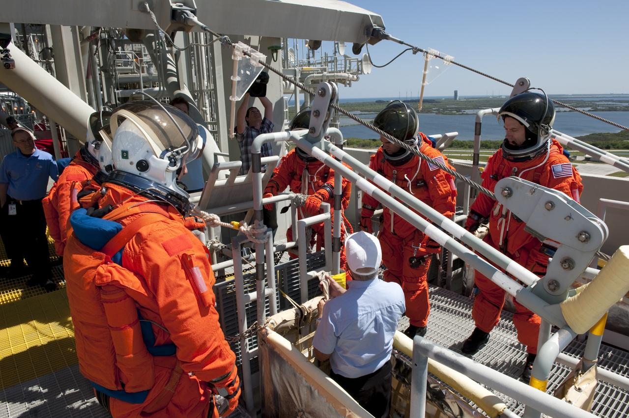 CAPE CANAVERAL, Fla. - During a simulated pad emergency on Launch Pad 39A at NASA's Kennedy Space Center in Florida, members of the STS-134 crew check out a slidewire basket that would take them to a safe bunker below the pad in an unlikely emergency situation. The emergency training while aboard space shuttle Endeavour is part of a week-long Terminal Countdown Demonstration Test (TCDT). Endeavour's six crew members are targeted to launch April 19 at 7:48 p.m. EDT. They will deliver the Express Logistics Carrier-3, Alpha Magnetic Spectrometer-2 (AMS), a high-pressure gas tank, additional spare parts for the Dextre robotic helper and micrometeoroid debris shields to the International Space Station. This will be the final spaceflight for Endeavour. For more information visit, www.nasa.gov/mission_pages/shuttle/shuttlemissions/sts134/index.html. Photo credit: NASA/Kim Shiflett