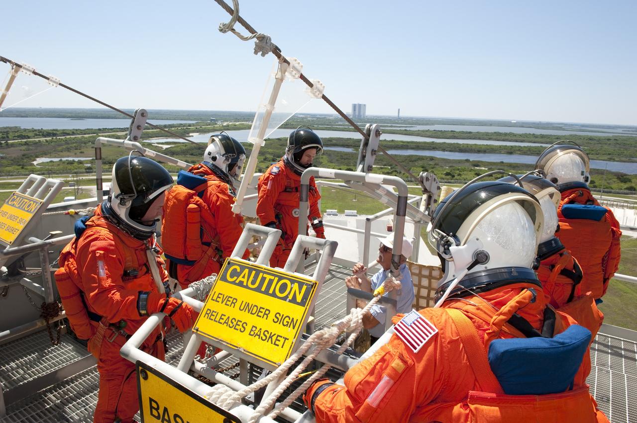 CAPE CANAVERAL, Fla. -- During a simulated pad emergency on Launch Pad 39A at NASA's Kennedy Space Center in Florida, members of the STS-134 crew check out a slidewire basket that would take them to a safe bunker below the pad in an unlikely emergency situation. The emergency training while aboard space shuttle Endeavour is part of a week-long Terminal Countdown Demonstration Test (TCDT). Endeavour's six crew members are targeted to launch April 19 at 7:48 p.m. EDT. They will deliver the Express Logistics Carrier-3, Alpha Magnetic Spectrometer-2 (AMS), a high-pressure gas tank, additional spare parts for the Dextre robotic helper and micrometeoroid debris shields to the International Space Station. This will be the final spaceflight for Endeavour. For more information visit, www.nasa.gov/mission_pages/shuttle/shuttlemissions/sts134/index.html. Photo credit: NASA/Kim Shiflett