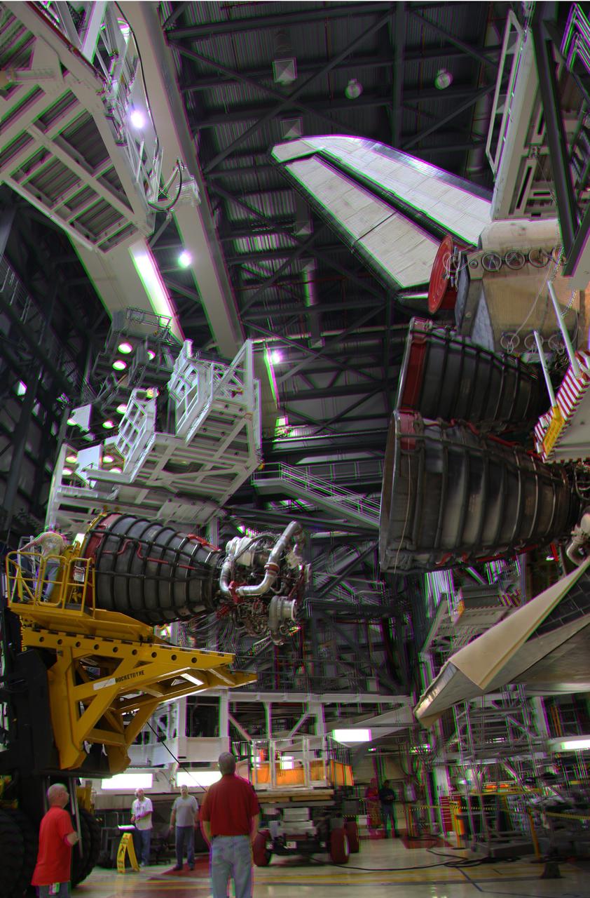 CAPE CANAVERAL, Fla. -- This is a 3-D image of crews in Orbiter Processing Facility-2 at NASA's Kennedy Space Center in Florida using a Hyster forklift to lower one of space shuttle Discovery's main engines after removal for cleaning and inspection. This is part of the spacecraft's transition and retirement processing and work performed on Discovery is expected to help rocket designers build next-generation spacecraft and prepare the shuttle for future public display. To view this image, use green and magenta 3-D glasses. Photo credit: NASA/Frankie Martin