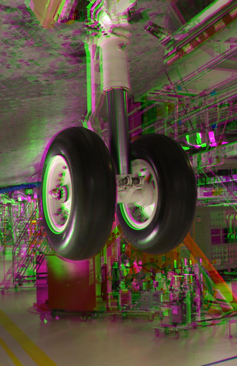 CAPE CANAVERAL, Fla. -- This 3-D image was taken in Orbiter Processing Facility-2 at NASA's Kennedy Space Center in Florida, after crews installed the final tire on space shuttle Discovery. This is part of the spacecraft's transition and retirement processing and work performed on Discovery is expected to help rocket designers build next-generation spacecraft and prepare the shuttle for future public display. To view this image, use green and magenta 3-D glasses. Photo credit: NASA/Frankie Martin