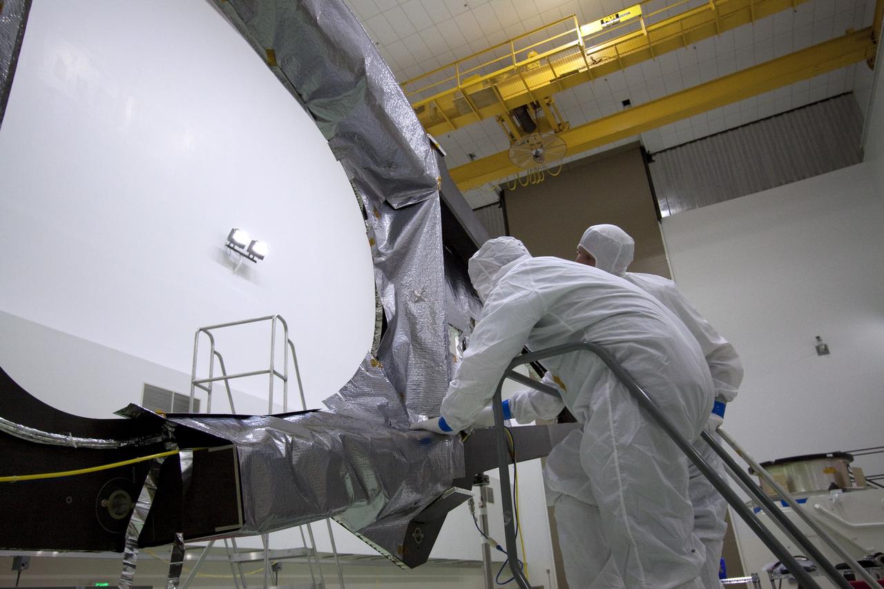 CAPE CANAVERAL, Fla. -- Technicians in the Astrotech payload processing facility in Titusville, Fla., install insulating blankets around a magnetometer boom. The boom structure is attached to Juno's solar array #1 that will help power the NASA spacecraft on its mission to Jupiter.  Juno is scheduled to launch aboard an Atlas V rocket from Cape Canaveral, Fla., on Aug. 5, 2011, reaching Jupiter in July 2016. The spacecraft will orbit the giant planet more than 30 times, skimming to within 3,000 miles above its cloud tops, for about one year. With its suite of science instruments, the spacecraft will investigate the existence of a solid planetary core, map Jupiter's intense magnetic field, measure the amount of water and ammonia in the deep atmosphere, and observe the planet's auroras. For more information visit, www.nasa.gov/juno. Photo credit: NASA/Jack Pfaller