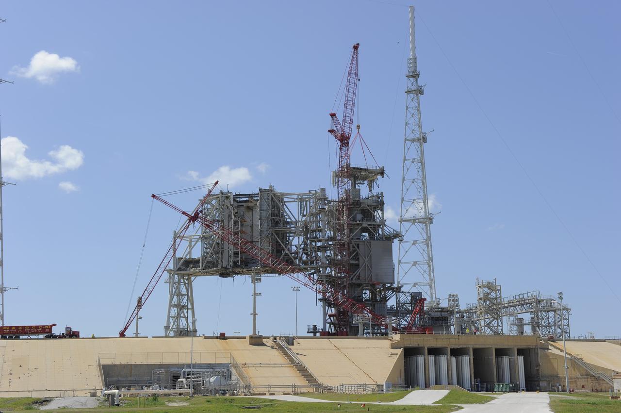 Cape Canaveral, Fla. -- A large crane dismantles another section of the fixed service structure (FSS) on Launch Pad 39B at NASA's Kennedy Space Center in Florida. Work to remove the rotating service structure (RSS) also continues at the pad. The FSS and RSS were designed to support the unique needs of the Space Shuttle Program. In 2009, the pad was no longer needed for the shuttle program, so it is being restructured for future use. Its new design will feature a "clean pad" for rockets to come with their own launcher, making it more versatile for a number of vehicles. The new lightning protection system, which was in place for the October 2009 launch of Ares I-X, will remain. For information on NASA's future plans, visit www.nasa.gov. Photo credit: NASA/Kim Shiflett