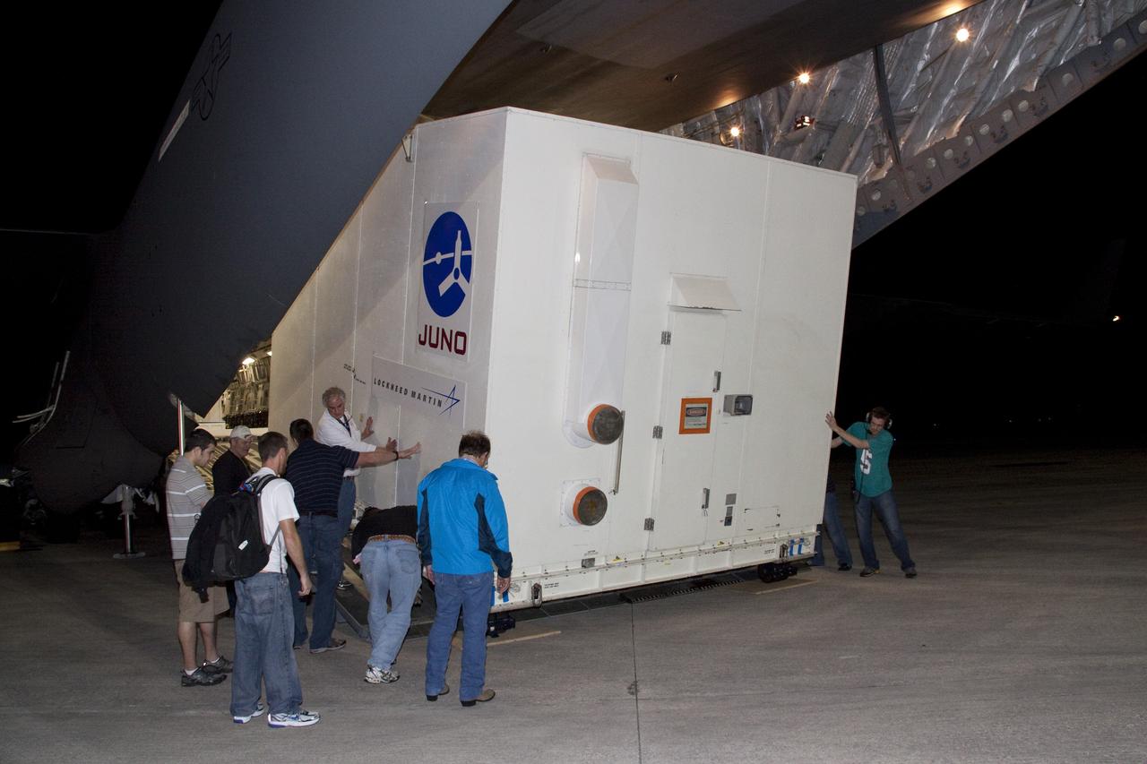 CAPE CANAVERAL, Fla. -- Workers guide the container holding NASA's Juno spacecraft down the ramp of an Air Force C-17 jet at Kennedy Space Center's Shuttle Landing Facility in Florida. Juno was shipped from Lockheed Martin Space Systems in Denver and will be transported to Astrotech's payload processing facility in Titusville, Fla. to begin final preparations for launch.              The solar-powered spacecraft will orbit Jupiter's poles 33 times to find out more about the gas giant's origins, structure, atmosphere and magnetosphere and investigate the existence of a solid planetary core. Juno is scheduled to launch aboard an Atlas V rocket from Cape Canaveral, Fla. Aug. 5. For more information visit, www.nasa.gov/juno. Photo credit: NASA/Jack Pfaller