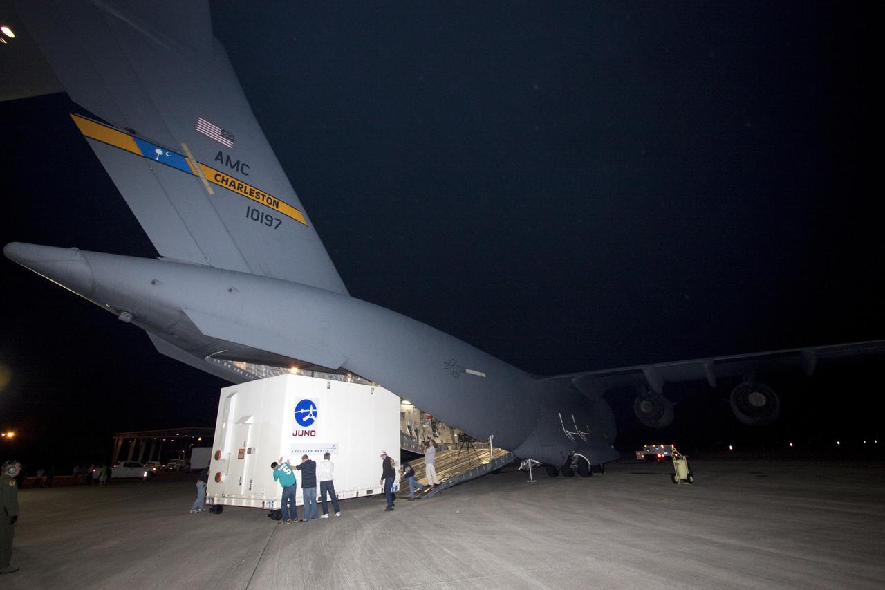 CAPE CANAVERAL, Fla. -- Workers move the container holding NASA's Juno spacecraft away from the ramp of an Air Force C-17 jet at Kennedy Space Center's Shuttle Landing Facility in Florida. Juno was shipped from Lockheed Martin Space Systems in Denver and will be transported to Astrotech's payload processing facility in Titusville, Fla. to begin final preparations for launch.                  The solar-powered spacecraft will orbit Jupiter's poles 33 times to find out more about the gas giant's origins, structure, atmosphere and magnetosphere and investigate the existence of a solid planetary core. Juno is scheduled to launch aboard an Atlas V rocket from Cape Canaveral, Fla. Aug. 5. For more information visit, www.nasa.gov/juno. Photo credit: NASA/Jack Pfaller
