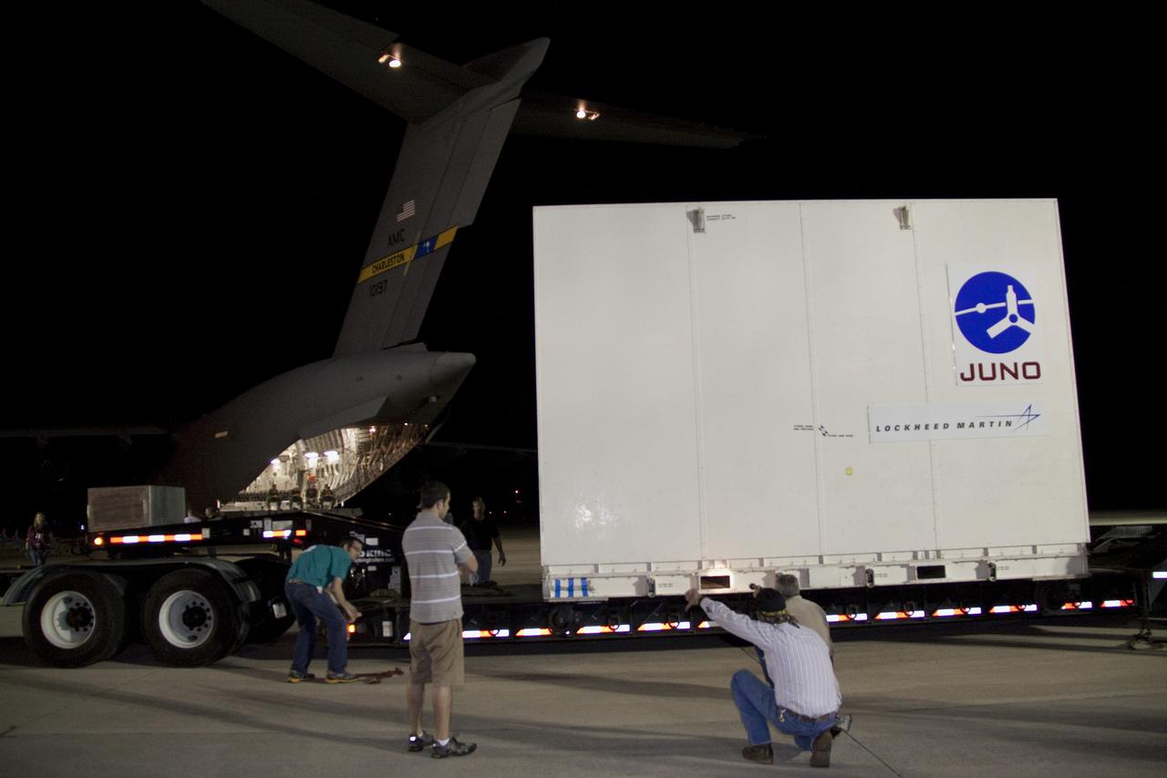 CAPE CANAVERAL, Fla. -- At the Shuttle Landing Facility at NASA's Kennedy Space Center in Florida, workers position the container holding NASA's Juno spacecraft on a truck that will transport it to Astrotech's payload processing facility in Titusville, Fla. to begin final preparations for launch.                      The solar-powered spacecraft will orbit Jupiter's poles 33 times to find out more about the gas giant's origins, structure, atmosphere and magnetosphere and investigate the existence of a solid planetary core. Juno is scheduled to launch aboard an Atlas V rocket from Cape Canaveral, Fla. Aug. 5. For more information visit, www.nasa.gov/juno. Photo credit: NASA/Jack Pfaller