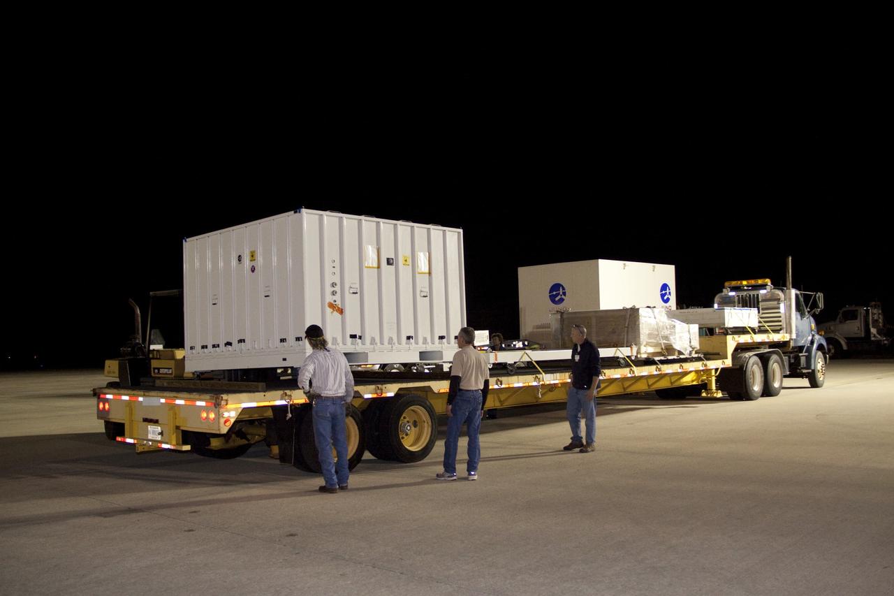 CAPE CANAVERAL, Fla. -- Workers move the container holding NASA Juno high-gain antenna container onto a transport at Kennedy Space Center's Shuttle Landing Facility in Florida. The spacecraft and its high-gain antenna was shipped from Lockheed Martin Space Systems in Denver and will be transported to Astrotech's payload processing facility in Titusville, Fla. to begin final preparations for launch. The solar-powered spacecraft will orbit Jupiter's poles 33 times to find out more about the gas giant's origins, structure, atmosphere and magnetosphere and investigate the existence of a solid planetary core. Juno is scheduled to launch aboard an Atlas V rocket from Cape Canaveral, Fla. Aug. 5. For more information visit, www.nasa.gov/juno. Photo credit: NASA/Jack Pfaller