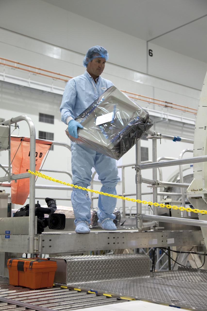 CAPE CANAVERAL, Fla. -- In the Space Station Processing Facility at NASA's Kennedy Space Center in Florida, a technician, garbed in protective wear, commonly known as a 'bunny suit,' carries equipment that will be installed into the Raffaello multi-purpose logistics module  for shuttle Atlantis' flight to the International Space Station.        Atlantis and its payload is being prepared for the STS-135 mission, which will deliver the Raffaello multi-purpose logistics module packed with supplies and spare parts to the station. Atlantis is targeted to launch June 28, and will be the last shuttle flight for the Space Shuttle Program. For more information visit, http://www.nasa.gov/mission_pages/shuttle/shuttlemissions/sts135/index.html. Photo credit: NASA/Frankie Martin