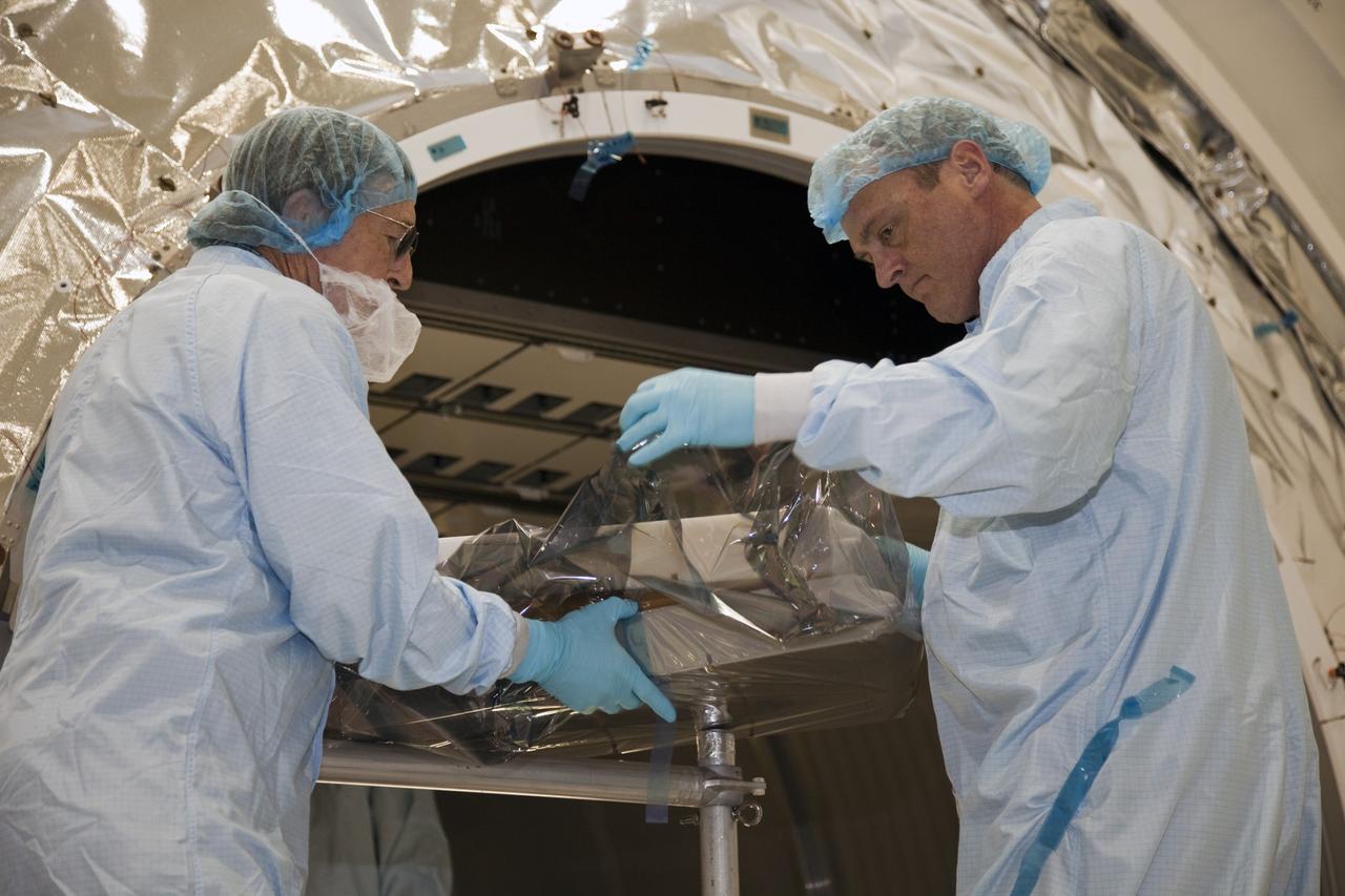 CAPE CANAVERAL, Fla. -- In the Space Station Processing Facility at NASA's Kennedy Space Center in Florida, technicians garbed in protective wear, commonly known as 'bunny suits,' check the protective wrapping of a piece of equipment prior to installation into the Raffaello multi-purpose logistics module for shuttle Atlantis' flight to the International Space Station.    Atlantis and its payload is being prepared for the STS-135 mission, which will deliver the Raffaello multi-purpose logistics module packed with supplies and spare parts to the station. Atlantis is targeted to launch June 28, and will be the last shuttle flight for the Space Shuttle Program. For more information visit, http://www.nasa.gov/mission_pages/shuttle/shuttlemissions/sts135/index.html. Photo credit: NASA/Frankie Martin