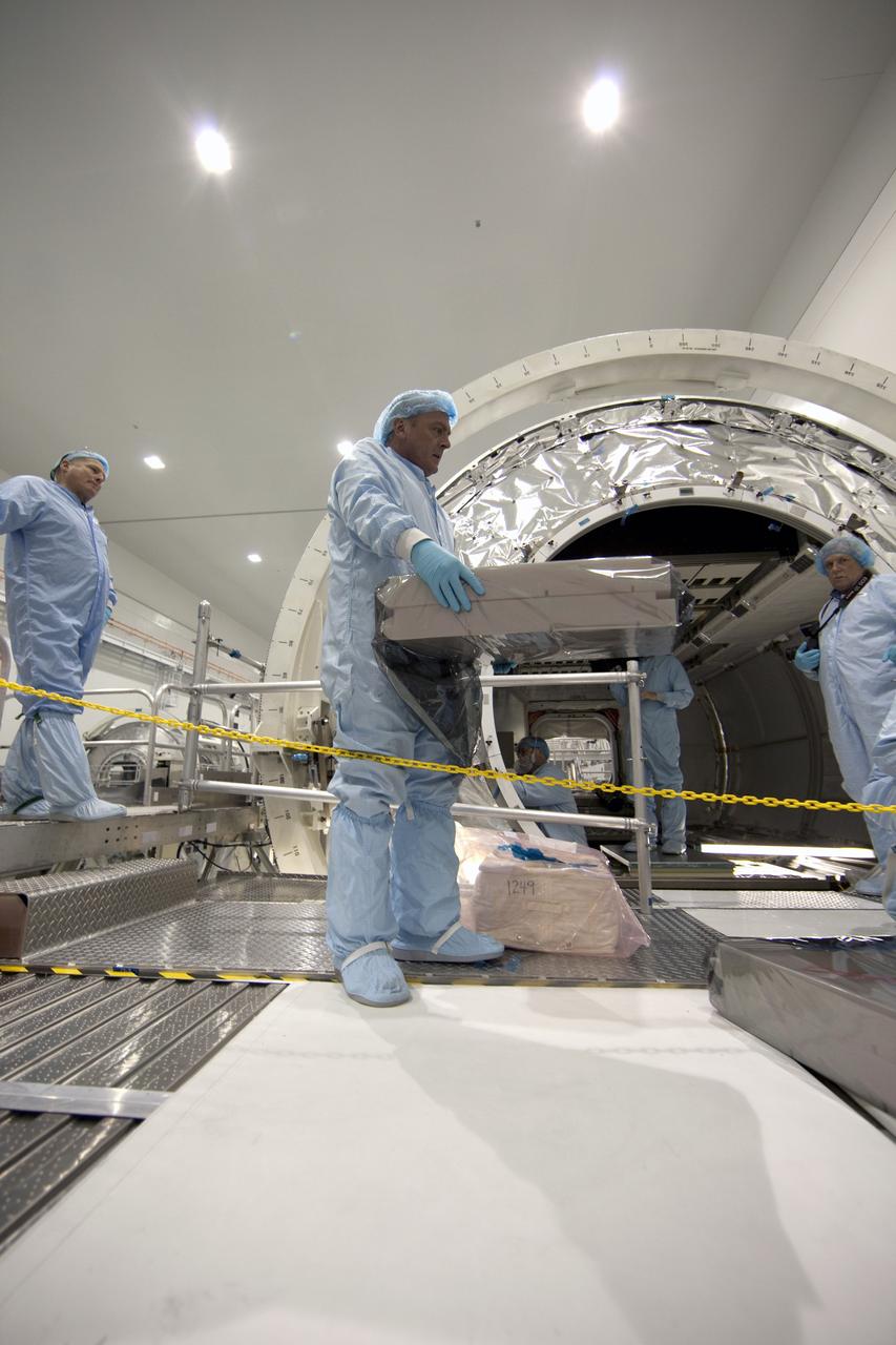 CAPE CANAVERAL, Fla. -- In the Space Station Processing Facility at NASA's Kennedy Space Center in Florida, technicians garbed in protective wear, commonly known as 'bunny suits,' install the cargo inside the Raffaello multi-purpose logistics module  for shuttle Atlantis' flight to the International Space Station.          Atlantis and its payload is being prepared for the STS-135 mission, which will deliver the Raffaello multi-purpose logistics module packed with supplies and spare parts to the station. Atlantis is targeted to launch June 28, and will be the last shuttle flight for the Space Shuttle Program. For more information visit, http://www.nasa.gov/mission_pages/shuttle/shuttlemissions/sts135/index.html. Photo credit: NASA/Frankie Martin