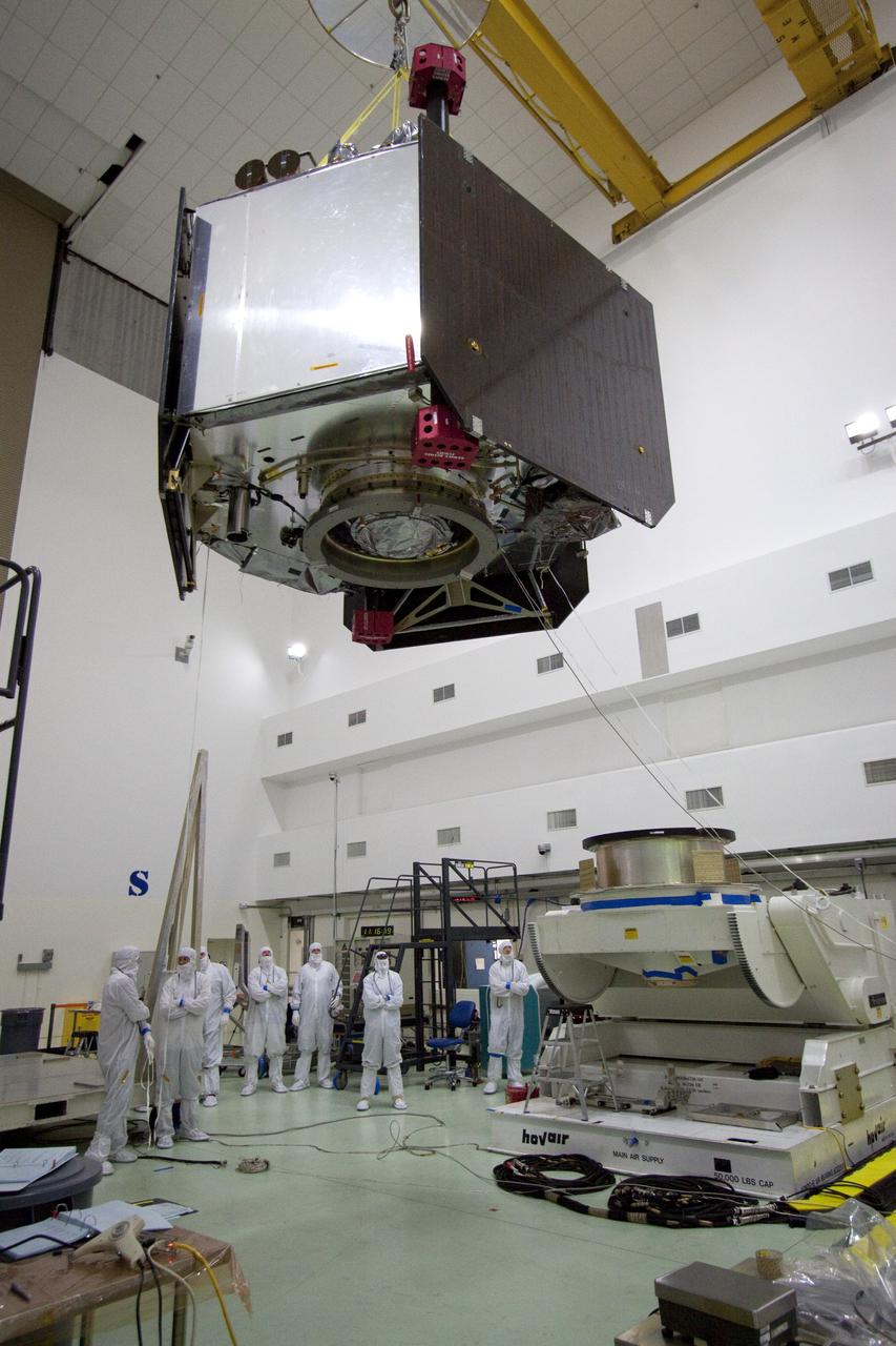 CAPE CANAVERAL, Fla. -- Technicians at Astrotech's payload processing facility in Titusville, Fla. monitor NASA's Juno spacecraft as it is moved by overhead crane to the rotation stand for testing.    The solar-powered spacecraft will orbit Jupiter's poles 33 times to find out more about the gas giant's origins, structure, atmosphere and magnetosphere and investigate the existence of a solid planetary core. Juno is scheduled to launch aboard an Atlas V rocket from Cape Canaveral, Fla. Aug. 5. For more information visit, www.nasa.gov/juno. Photo credit: NASA/Jack Pfaller