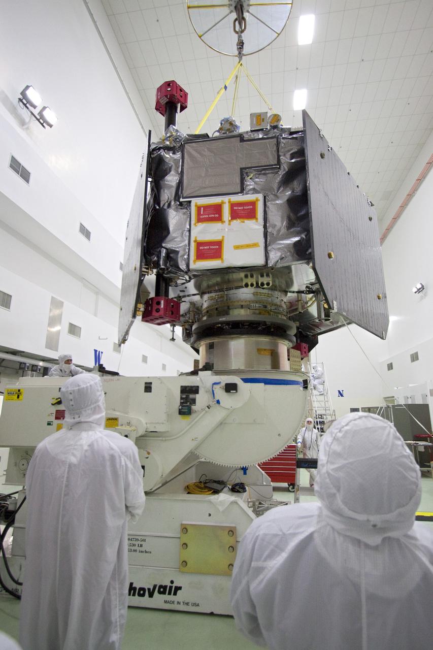 CAPE CANAVERAL, Fla. -- Technicians at Astrotech's payload processing facility in Titusville, Fla. guide NASA's Juno spacecraft, as it is lowered by overhead crane, onto the rotation stand for testing.          The solar-powered spacecraft will orbit Jupiter's poles 33 times to find out more about the gas giant's origins, structure, atmosphere and magnetosphere and investigate the existence of a solid planetary core. Juno is scheduled to launch aboard an Atlas V rocket from Cape Canaveral, Fla. Aug. 5. For more information visit, www.nasa.gov/juno. Photo credit: NASA/Jack Pfaller