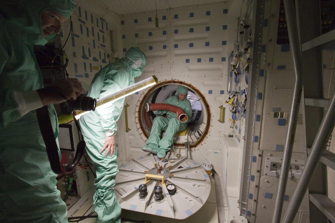 CAPE CANAVERAL, Fla. -- In the Space Station Processing Facility at NASA's Kennedy Space Center in Florida, STS-135 Mission Specialist Sandy Magnus crawls through a hatch with the aid of technicians while inspecting the mid-deck of shuttle Atlantis. The four-member crew is at Kennedy participating in the Crew Equipment Interface Test (CEIT), which gives them an opportunity for hands-on training with the spacecraft and familiarization of the payload they'll deliver to the International Space Station.     Atlantis and its payload is being prepared for the STS-135 mission, which will deliver the Raffaello multi-purpose logistics module packed with supplies and spare parts to the station. Atlantis is targeted to launch June 28, and will be the last shuttle flight for the Space Shuttle Program. For more information visit, http://www.nasa.gov/mission_pages/shuttle/shuttlemissions/sts135/index.html. Photo credit: NASA/Frankie Martin