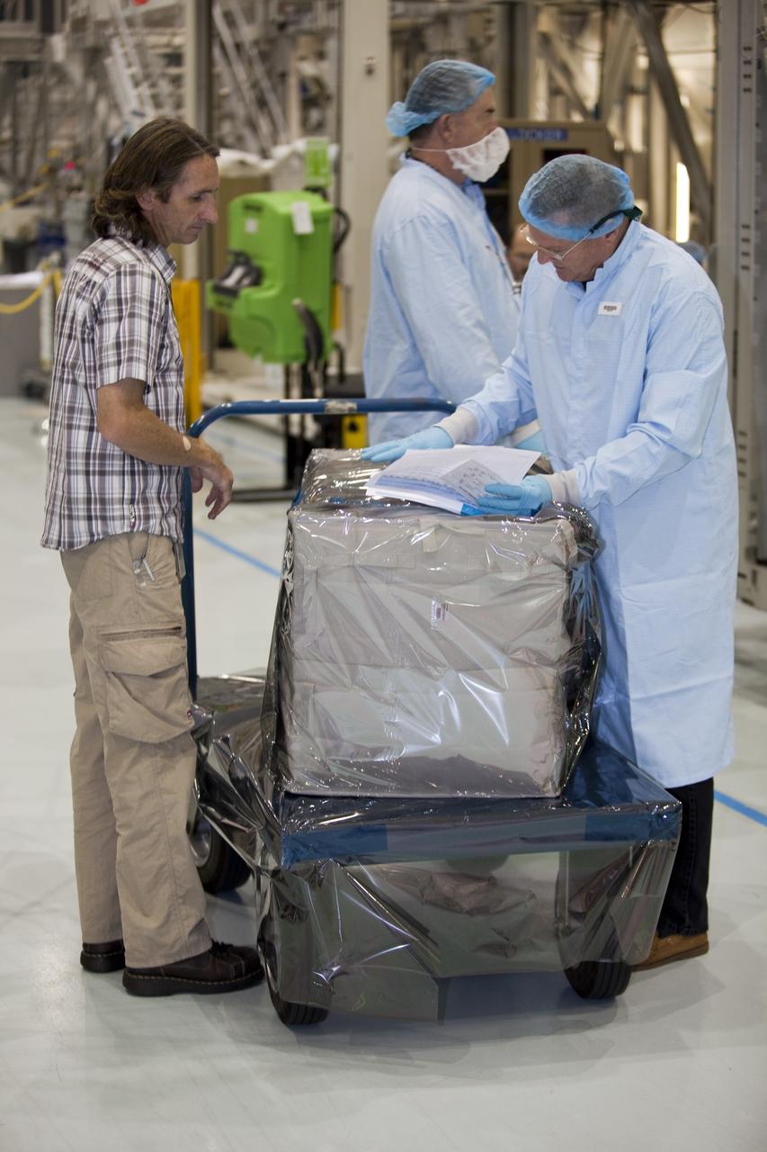 CAPE CANAVERAL, Fla. -- In the Space Station Processing Facility at NASA's Kennedy Space Center in Florida, technicians garbed in protective wear, commonly known as 'bunny suits,' and a worker checks the cargo that will be installed inside the Raffaello multi-purpose logistics module for shuttle Atlantis' flight to the International Space Station. Atlantis and its payload is being prepared for the STS-135 mission, which will deliver the Raffaello multi-purpose logistics module packed with supplies and spare parts to the station. Atlantis is targeted to launch June 28, and will be the last shuttle flight for the Space Shuttle Program. For more information visit, http://www.nasa.gov/mission_pages/shuttle/shuttlemissions/sts135/index.html. Photo credit: NASA/Frankie Martin