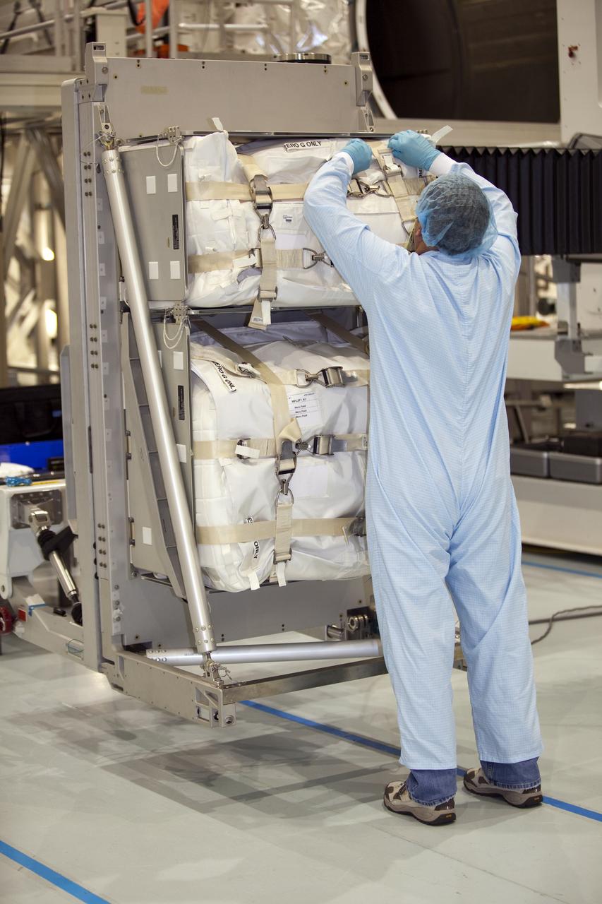 In the Space Station Processing Facility at NASA's Kennedy Space Center in Florida, a technician garbed in protective wear, commonly known as a 'bunny suit,' secures the cargo that will be installed inside the Raffaello multi-purpose logistics module for shuttle Atlantis' flight to the International Space Station. Atlantis and its payload is being prepared for the STS-135 mission, which will deliver the Raffaello multi-purpose logistics module packed with supplies and spare parts to the station. Atlantis is targeted to launch June 28, and will be the last shuttle flight for the Space Shuttle Program. For more information visit, http://www.nasa.gov/mission_pages/shuttle/shuttlemissions/sts135/index.html. Photo credit: NASA/Frankie Martin
