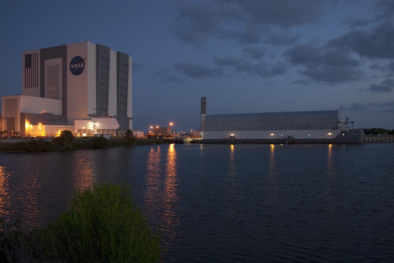 CAPE CANAVERAL, Fla. -- Viewed from across the Turn Basin in the Launch Complex 39 area at NASA's Kennedy Space Center in Florida, the Pegasus Barge is bathed in lights. The barge is being prepared to be towed from the dock to a more secure mooring area. The barge is 266 ft long and 50 ft wide and has been used by the Space Shuttle Program to transport external fuel tanks over 900 miles of inland and open ocean waterways from the Michoud Assembly Facility in Louisiana to Kennedy. Photo credit: NASA/Jim Grossmann