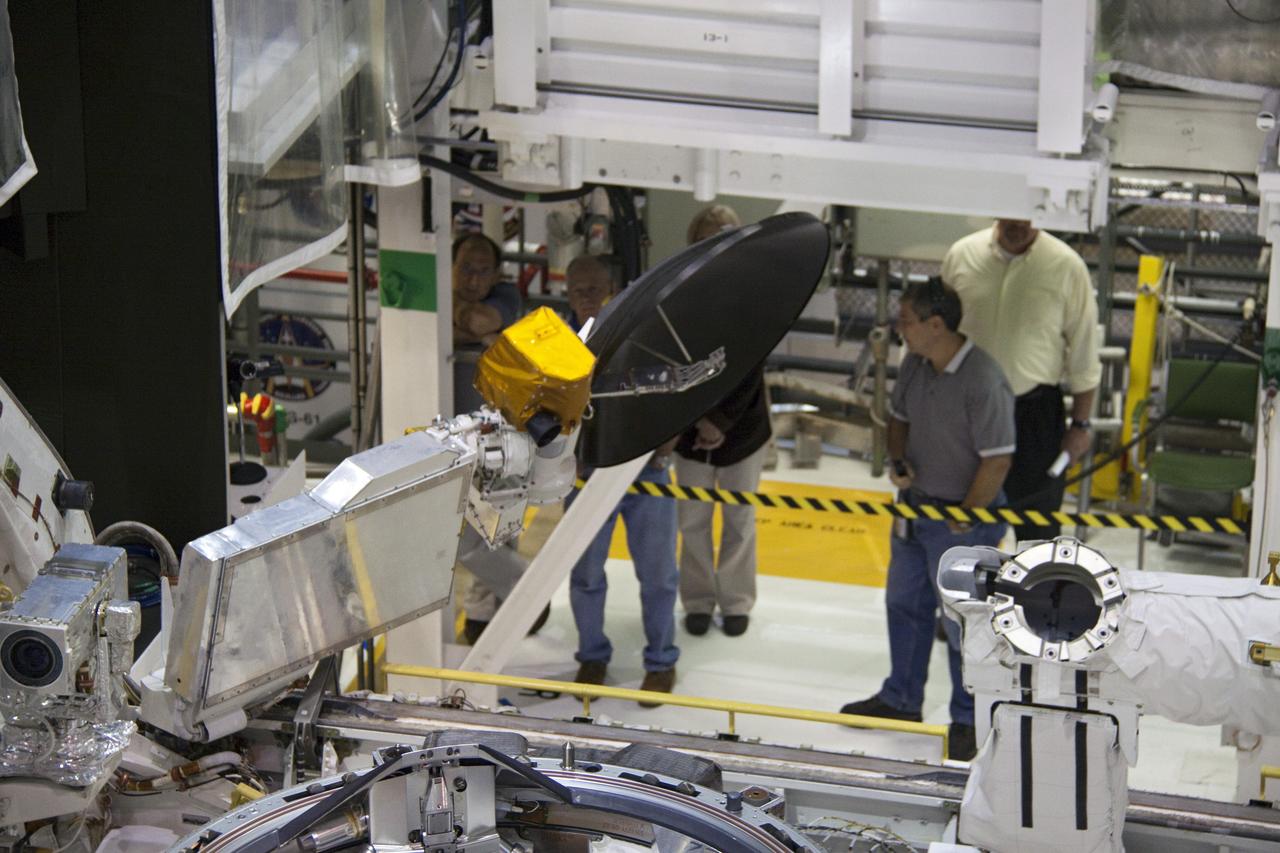 CAPE CANAVERAL, Fla. - In Orbiter Processing Facility-1 at NASA's Kennedy Space Center in Florida, the Ku-band antenna is being stowed in space shuttle Atlantis' payload bay. The antenna, which resembles a mini-satellite dish, transmits audio, video and data between Earth and the shuttle. Next, the clamshell doors of the payload bay will close completely in preparation for its move to the Vehicle Assembly Building. Atlantis is being prepared for the STS-135 mission, which will deliver the Raffaello multipurpose logistics module packed with supplies, logistics and spare parts to the International Space Station. STS-135 is targeted to launch June 28, and will be the last spaceflight for the Space Shuttle Program. Photo credit: NASA/Jack Pfaller