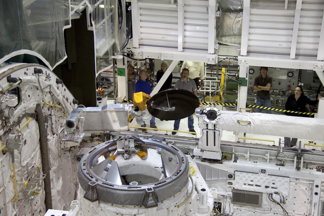 CAPE CANAVERAL, Fla. - In Orbiter Processing Facility-1 at NASA's Kennedy Space Center in Florida, the Ku-band antenna is being stowed in space shuttle Atlantis' payload bay. The antenna, which resembles a mini-satellite dish, transmits audio, video and data between Earth and the shuttle. Next, the clamshell doors of the payload bay will close completely in preparation for its move to the Vehicle Assembly Building. Atlantis is being prepared for the STS-135 mission, which will deliver the Raffaello multipurpose logistics module packed with supplies, logistics and spare parts to the International Space Station. STS-135 is targeted to launch June 28, and will be the last spaceflight for the Space Shuttle Program. Photo credit: NASA/Jack Pfaller