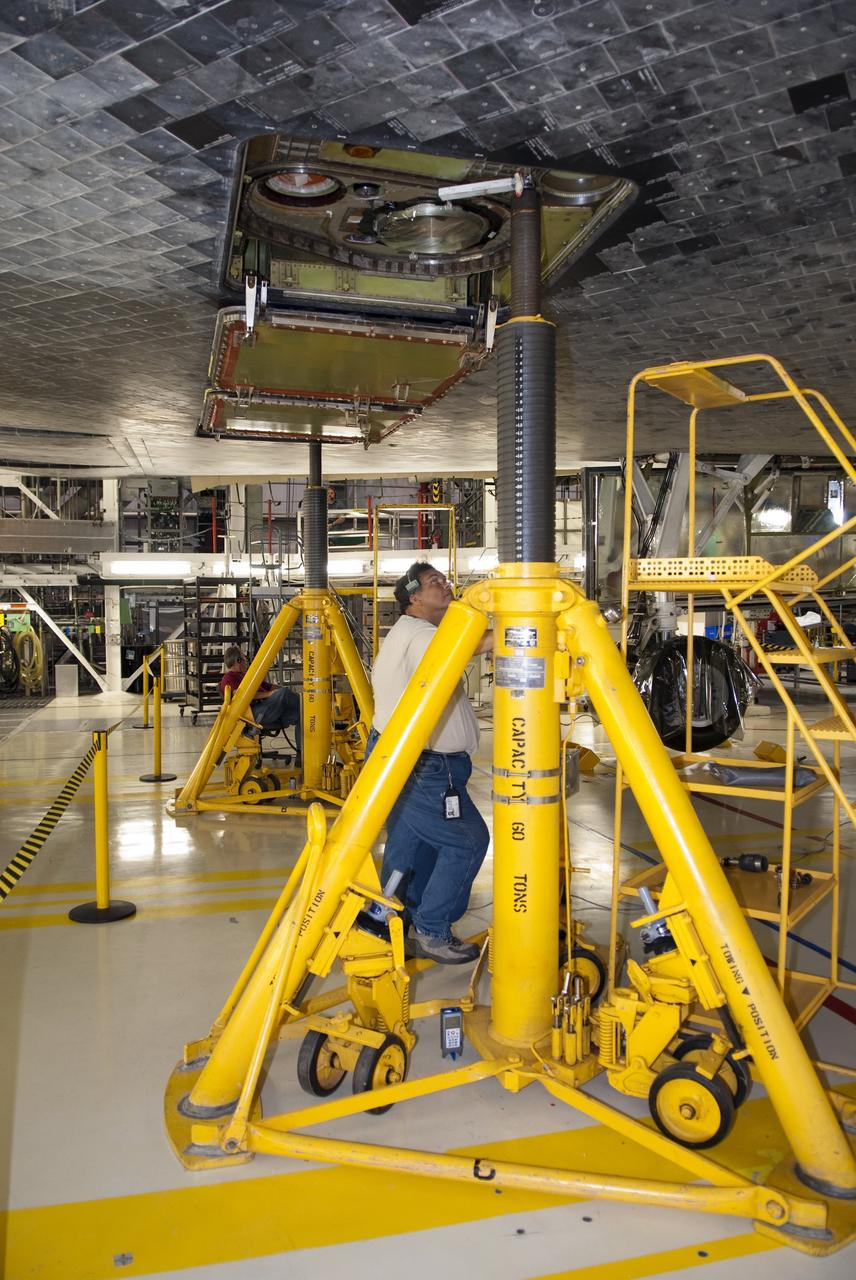 CAPE CANAVERAL, Fla. - In Orbiter Processing Facility-1 at NASA's Kennedy Space Center in Florida, workers install and test the hydraulic system that will lift the shuttle Atlantis off the floor to enable the orbiter transport system, or OTS, to be rolled underneath for its move, or "rollover," to the Vehicle Assembly Building. Once there Atlantis will be joined with the external fuel tank and solid rocket boosters on the mobile launcher platform. Atlantis is being prepared for the STS-135 mission, which will deliver the Raffaello multipurpose logistics module packed with supplies, logistics and spare parts to the International Space Station. STS-135 is targeted to launch June 28, and will be the last spaceflight for the Space Shuttle Program. Photo credit: NASA/Jim Grossmann