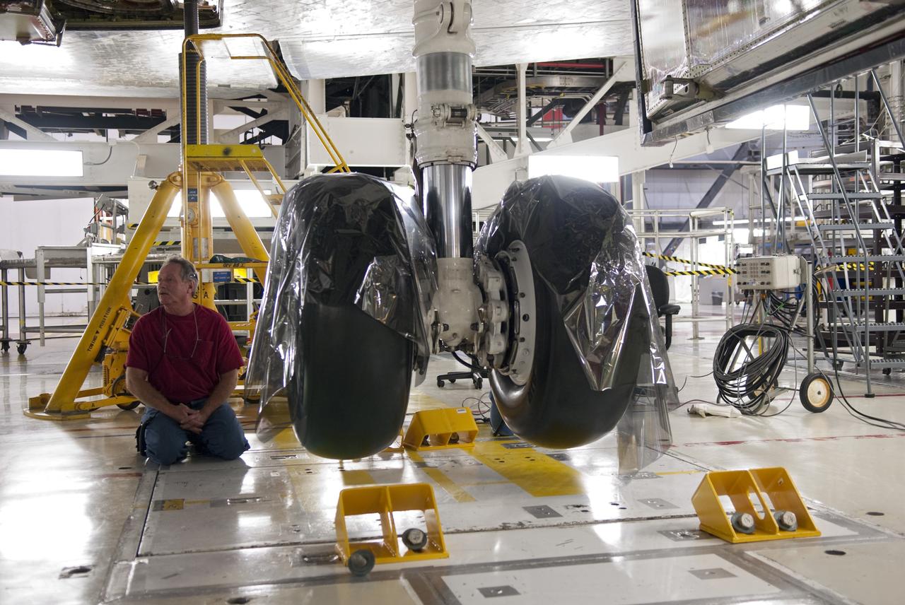CAPE CANAVERAL, Fla. - In Orbiter Processing Facility-1 at NASA's Kennedy Space Center in Florida, a worker checks the hydraulic system that has lifted shuttle Atlantis off the floor to enable the orbiter transport system, or OTS, to be rolled underneath for its move, or "rollover," to the Vehicle Assembly Building. Once there Atlantis will be joined with the external fuel tank and solid rocket boosters on the mobile launcher platform. Atlantis is being prepared for the STS-135 mission, which will deliver the Raffaello multipurpose logistics module packed with supplies, logistics and spare parts to the International Space Station. STS-135 is targeted to launch June 28, and will be the last spaceflight for the Space Shuttle Program. Photo credit: NASA/Jim Grossmann