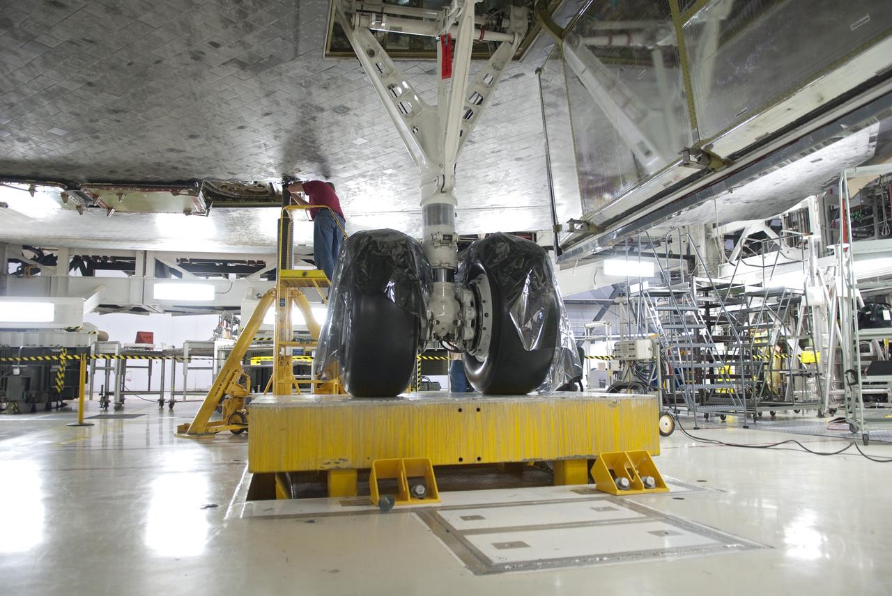 CAPE CANAVERAL, Fla. - In Orbiter Processing Facility-1 at NASA's Kennedy Space Center in Florida, a worker checks the hydraulic system that has lifted shuttle Atlantis off the floor to enable the orbiter transport system, or OTS, to be rolled underneath for its move, or "rollover," to the Vehicle Assembly Building. Once there Atlantis will be joined with the external fuel tank and solid rocket boosters on the mobile launcher platform. Atlantis is being prepared for the STS-135 mission, which will deliver the Raffaello multipurpose logistics module packed with supplies, logistics and spare parts to the International Space Station. STS-135 is targeted to launch June 28, and will be the last spaceflight for the Space Shuttle Program. Photo credit: NASA/Jim Grossmann
