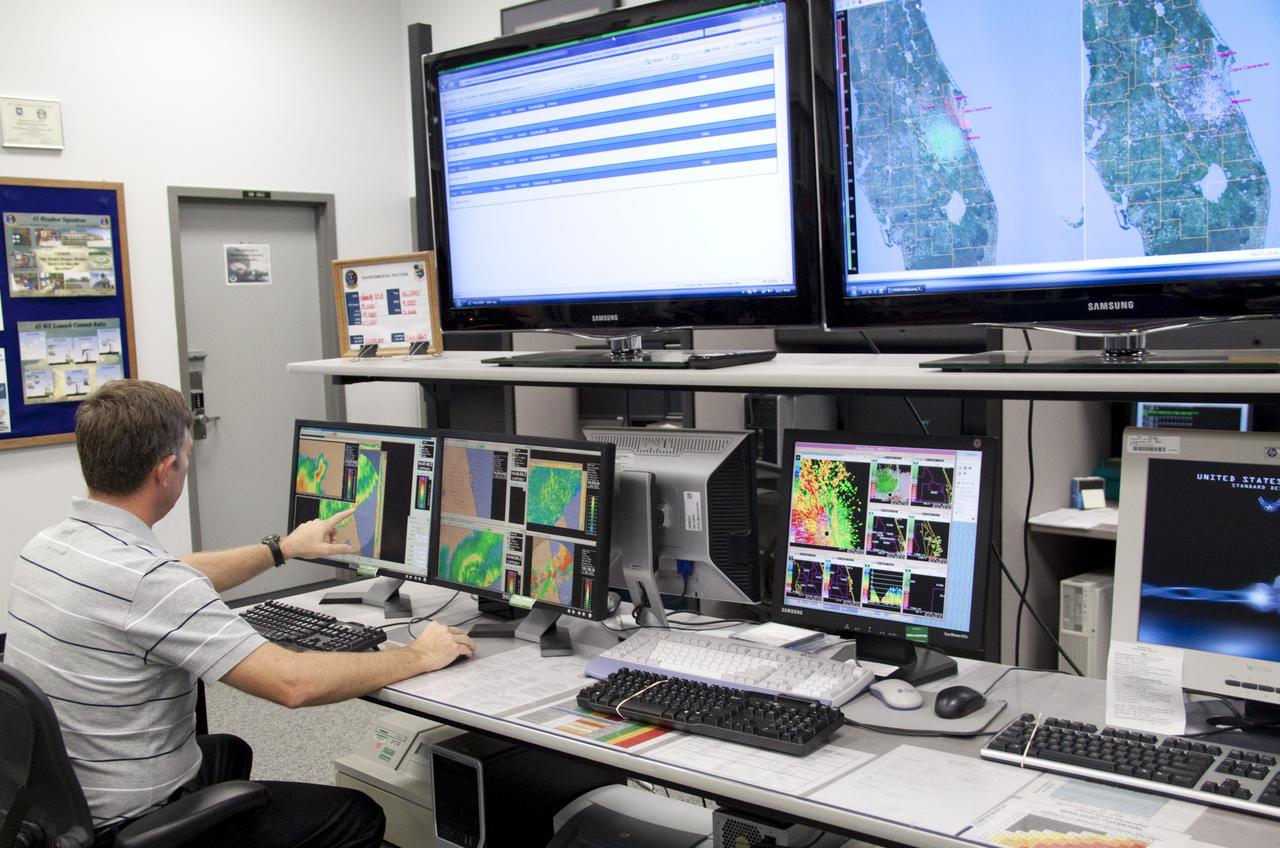 CAPE CANAVERAL, Fla. - At the Cape Canaveral Air Force Station forecast facility in Florida, a member of the weather team demonstrates the effectiveness of the new weather radar display recently installed. The facility is operated by the U.S. Air Force 45th Weather Squadron and will generate a launch weather forecast for the scheduled July 8 lift off of space shuttle Atlantis on the STS-135 mission. Photo credit: NASA/Jack Pfaller