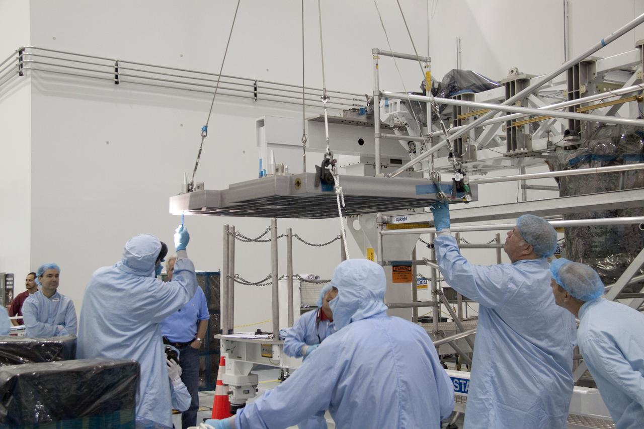 CAPE CANAVERAL, Fla. - In the Space Station Processing Facility at NASA's Kennedy Space Center in Florida, technicians guide an overhead crane as it lifts the pump module assembly plate for transfer to the Lightweight Multi-Purpose Experiment Support Structure Carrier, or LMC. The module assembly will be used to secure the return of a failed ammonia pump module in shuttle Atlantis' payload bay. Atlantis and its payload are being prepared for the STS-135 mission, which will deliver the Raffaello multipurpose logistics module packed with supplies, logistics and spare parts to the International Space Station. STS-135 is targeted to launch June 28, and will be the last spaceflight for the Space Shuttle Program. Photo credit: NASA/Jack Pfaller