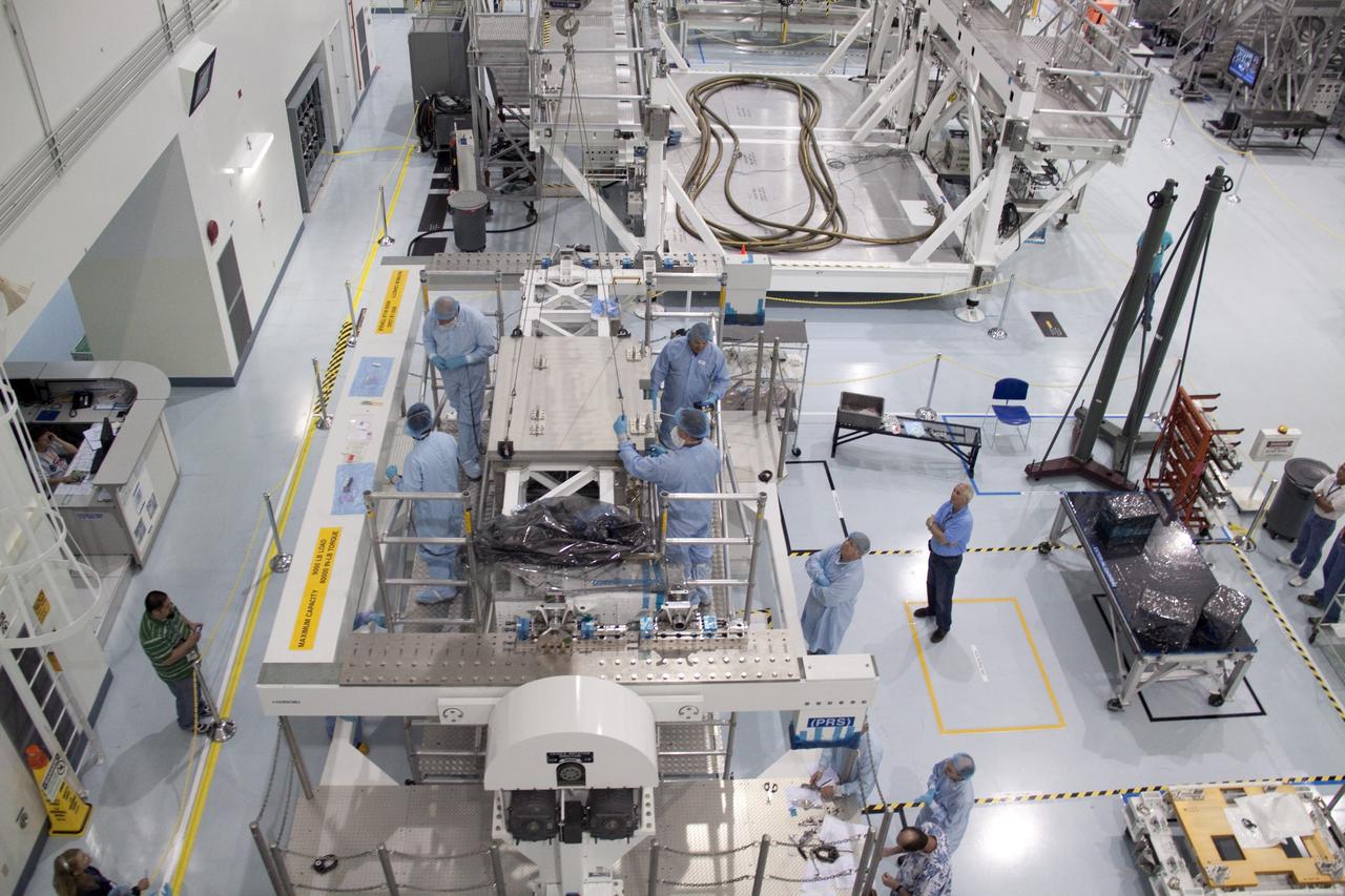 CAPE CANAVERAL, Fla. - In the Space Station Processing Facility at NASA's Kennedy Space Center in Florida, technicians secure the pump module assembly plate into position onto the Lightweight Multi-Purpose Experiment Support Structure Carrier, or LMC. The module assembly will be used to secure the return of a failed ammonia pump module in shuttle Atlantis' payload bay. Atlantis and its payload are being prepared for the STS-135 mission, which will deliver the Raffaello multipurpose logistics module packed with supplies, logistics and spare parts to the International Space Station. STS-135 is targeted to launch June 28, and will be the last spaceflight for the Space Shuttle Program. Photo credit: NASA/Jack Pfaller