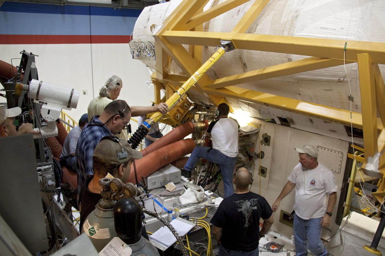 CAPE CANAVERAL, Fla. - In Orbiter Processing Facility-2 at NASA's Kennedy Space Center in Florida, workers prepare to remove shuttle Discovery's right-hand orbital maneuvering system, or OMS, pod. The removal is part of Discovery's transition and retirement processing. Work performed on Discovery is expected to help rocket designers build next-generation spacecraft and prepare the shuttle for future public display. Photo credit: NASA/Troy Cryder
