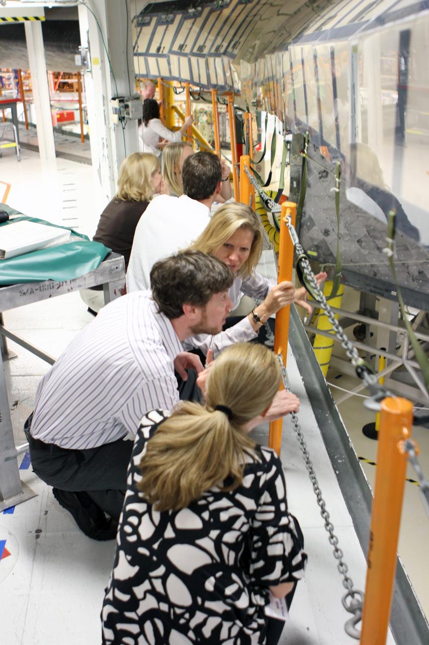 CAPE CANAVERAL, Fla. -- NASA's Stephanie Stilson (facing camera), flow director for space shuttle Discovery, discusses Discovery's thermal protection system with members of a visiting team from the Smithsonian's National Air and Space Museum in Orbiter Processing Facility-2 at NASA's Kennedy Space Center. NASA Administrator Charles Bolden announced April 12 the facilities where all four shuttle orbiters will be permanently displayed at the conclusion of the Space Shuttle Program. Shuttle Enterprise, the first orbiter built, will move from the Smithsonian's National Air and Space Museum Steven F. Udvar-Hazy Center in Virginia to the Intrepid Sea, Air & Space Museum in New York. The Udvar-Hazy Center will become the new home for shuttle Discovery, which retired in March after completing its 39th mission. Shuttle Endeavour, which is preparing for its final flight at the end of the month, will go to the California Science Center in Los Angeles. Atlantis, which will fly the last planned shuttle mission in June, will be displayed at the Kennedy Space Center Visitor Complex in Florida. Photo credit: NASA/Cory Huston