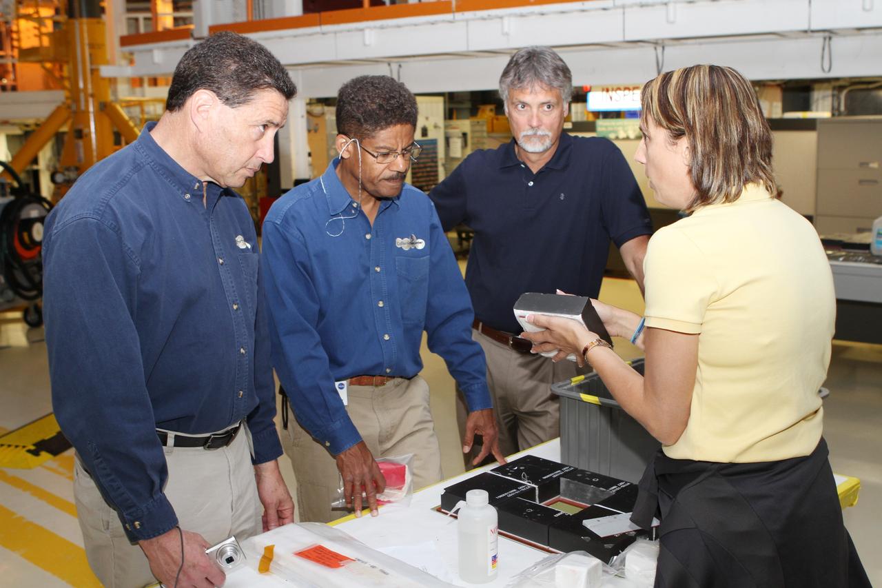 CAPE CANAVERAL, Fla. -- Members of a visiting team from the Smithsonian's National Air and Space Museum receive a briefing on the application of the space shuttle's thermal protection system tile in Orbiter Processing Facility-2 at NASA's Kennedy Space Center. NASA Administrator Charles Bolden announced April 12 the facilities where all four shuttle orbiters will be permanently displayed at the conclusion of the Space Shuttle Program. Shuttle Enterprise, the first orbiter built, will move from the Smithsonian's National Air and Space Museum Steven F. Udvar-Hazy Center in Virginia to the Intrepid Sea, Air & Space Museum in New York. The Udvar-Hazy Center will become the new home for shuttle Discovery, which retired in March after completing its 39th mission. Shuttle Endeavour, which is preparing for its final flight at the end of the month, will go to the California Science Center in Los Angeles. Atlantis, which will fly the last planned shuttle mission in June, will be displayed at the Kennedy Space Center Visitor Complex in Florida. Photo credit: NASA/Cory Huston