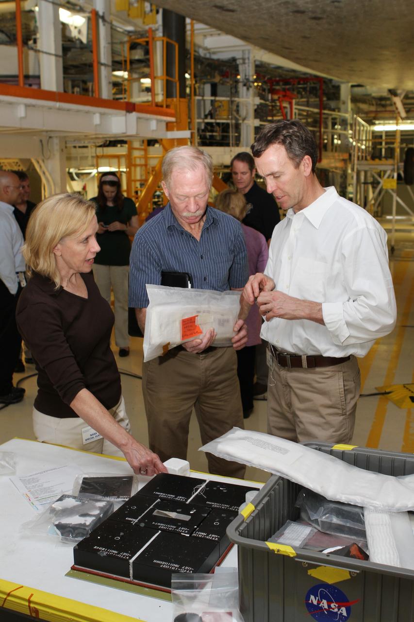 CAPE CANAVERAL, Fla. -- Members of a visiting team from the Smithsonian's National Air and Space Museum examine the space shuttle's thermal protection system tile as they stand beneath shuttle Discovery in Orbiter Processing Facility-2 at NASA's Kennedy Space Center. NASA Administrator Charles Bolden announced April 12 the facilities where all four shuttle orbiters will be permanently displayed at the conclusion of the Space Shuttle Program. Shuttle Enterprise, the first orbiter built, will move from the Smithsonian's National Air and Space Museum Steven F. Udvar-Hazy Center in Virginia to the Intrepid Sea, Air & Space Museum in New York. The Udvar-Hazy Center will become the new home for shuttle Discovery, which retired in March after completing its 39th mission. Shuttle Endeavour, which is preparing for its final flight at the end of the month, will go to the California Science Center in Los Angeles. Atlantis, which will fly the last planned shuttle mission in June, will be displayed at the Kennedy Space Center Visitor Complex in Florida. Photo credit: NASA/Cory Huston