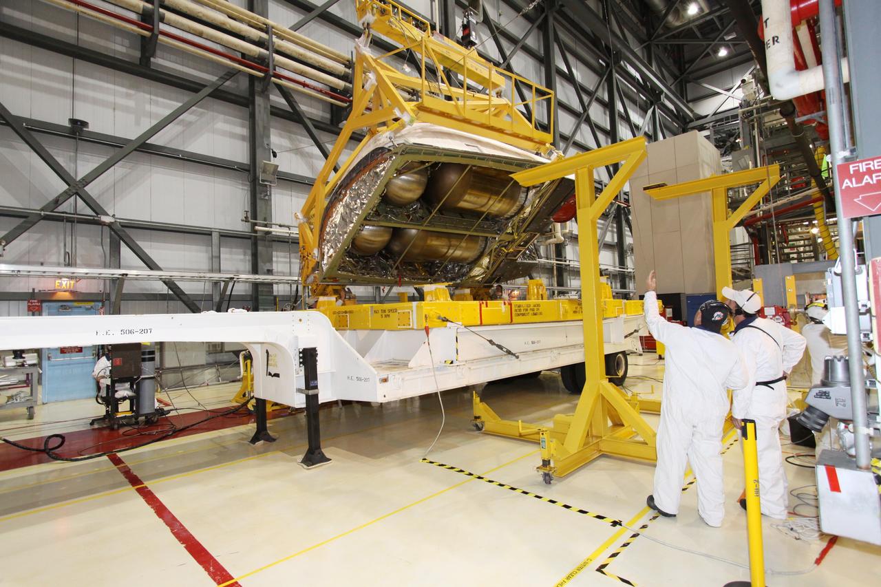 CAPE CANAVERAL, Fla. -- In Orbiter Processing Facility-2 at NASA's Kennedy Space Center in Florida, workers monitor an overhead crane as it lowers shuttle Discovery's right-hand orbital maneuvering system, or OMS, pod toward a transporter. It then will be moved to the Hypergol Maintenance Facility. The removal is part of Discovery's transition and retirement processing. Work performed on Discovery is expected to help rocket designers build next-generation spacecraft and prepare the shuttle for future public display. Photo credit: NASA/Jack Pfaller