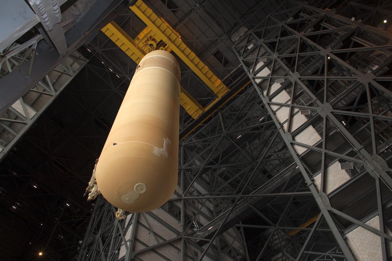 CAPE CANAVERAL, Fla. - In the Vehicle Assembly Building (VAB) at NASA's Kennedy Space Center in Florida, external fuel tank, ET-138, for space shuttle Atlantis' STS-135 mission, is lowered into high bay-1 for joining with the twin solid rocket boosters on the mobile launcher platform. Shuttle Atlantis' move, or "rollover," from Orbiter Processing Facility-1 to the VAB is targeted for May 10. Once there it will be mated with the external tank and boosters. Atlantis and its crew of four will deliver the Raffaello multipurpose logistics module packed with supplies and spare parts to the International Space Station. STS-135 is targeted to launch June 28, and will be the last spaceflight for the Space Shuttle Program. Photo credit: NASA/Jack Pfaller