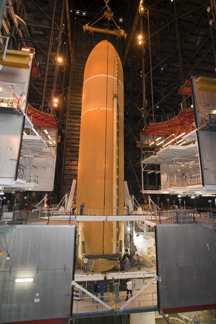 CAPE CANAVERAL, Fla. - In the Vehicle Assembly Building (VAB) at NASA's Kennedy Space Center in Florida, workers monitor the progress of external fuel tank, ET-138, for space shuttle Atlantis' STS-135 mission, as it is lowered into high bay-1 between the twin solid rocket boosters on the mobile launcher platform. Shuttle Atlantis' move, or "rollover," from Orbiter Processing Facility-1 to the VAB is targeted for May 10. Once there it will be mated with the external tank and boosters. Atlantis and its crew of four will deliver the Raffaello multipurpose logistics module packed with supplies and spare parts to the International Space Station. STS-135 is targeted to launch June 28, and will be the last spaceflight for the Space Shuttle Program. Photo credit: NASA/Jack Pfaller