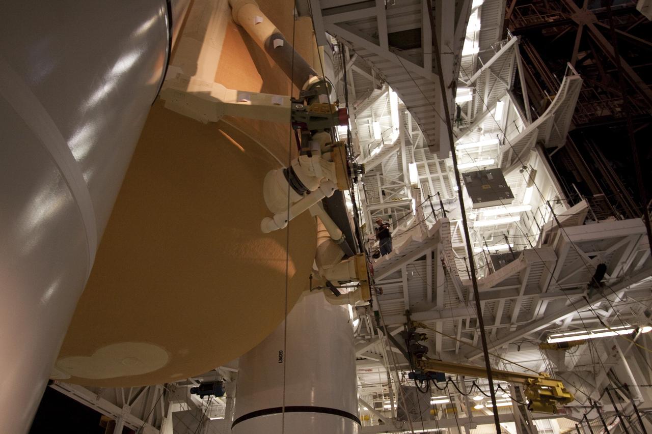 CAPE CANAVERAL, Fla. - In the Vehicle Assembly Building (VAB) at NASA's Kennedy Space Center in Florida, workers guide external fuel tank, ET-138, for space shuttle Atlantis' STS-135 mission, as it is lowered into high bay-1 between the twin solid rocket boosters on the mobile launcher platform. Shuttle Atlantis' move, or "rollover," from Orbiter Processing Facility-1 to the VAB is targeted for May 10. Once there it will be mated with the external tank and boosters. Atlantis and its crew of four will deliver the Raffaello multipurpose logistics module packed with supplies and spare parts to the International Space Station. STS-135 is targeted to launch June 28, and will be the last spaceflight for the Space Shuttle Program. Photo credit: NASA/Jack Pfaller
